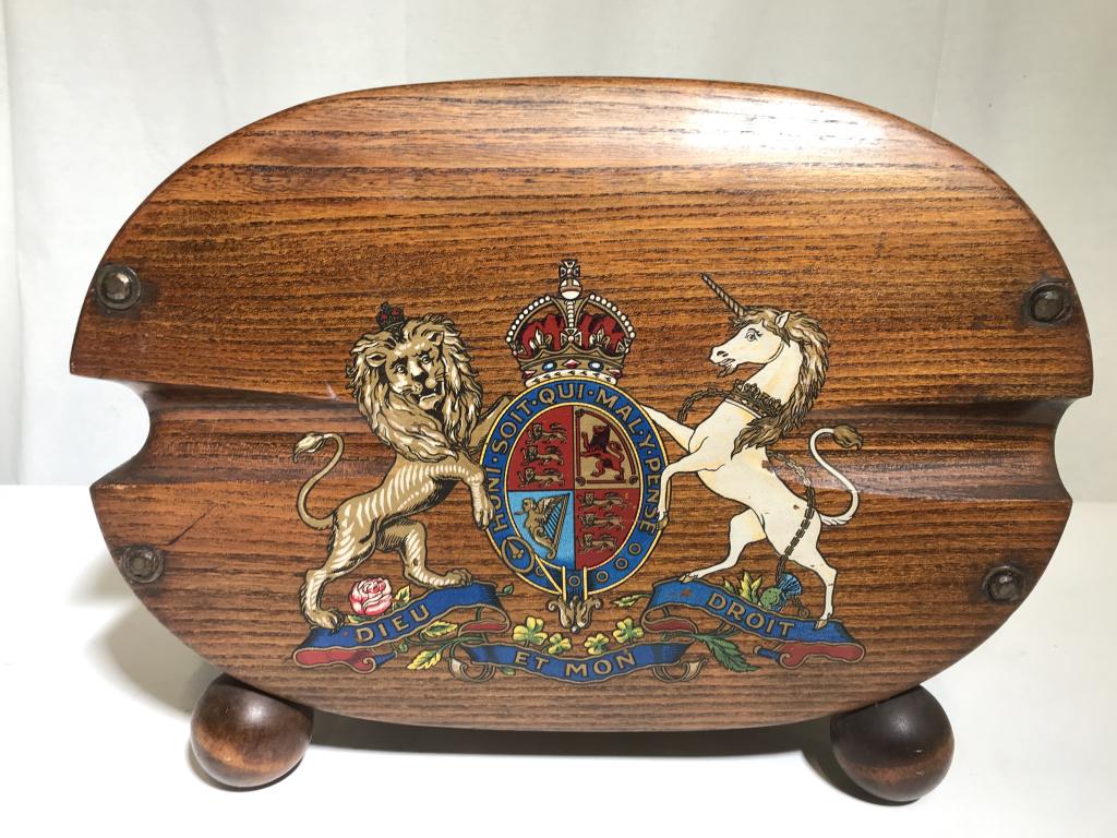 Vintage Wooden Coat of Arms Magazine Rack, England: This piece is a vintage, hand painted magazine rack. The piece is decorated with the Coat of Arms of the United Kingdom. The piece is crafted from wood, and features brass handles and round, spherical