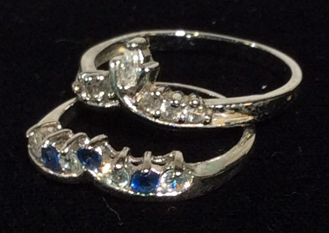 Lot 3 Contemporary Rhinestone Cocktail Rings: Solitaire rhinestone Ring, 8 mm large center stone flanked by a heart shape and clear diamanté cluster. In polished silver tone metal, size 10. Coordinating ‘crown rings’, one all clear rhineston
