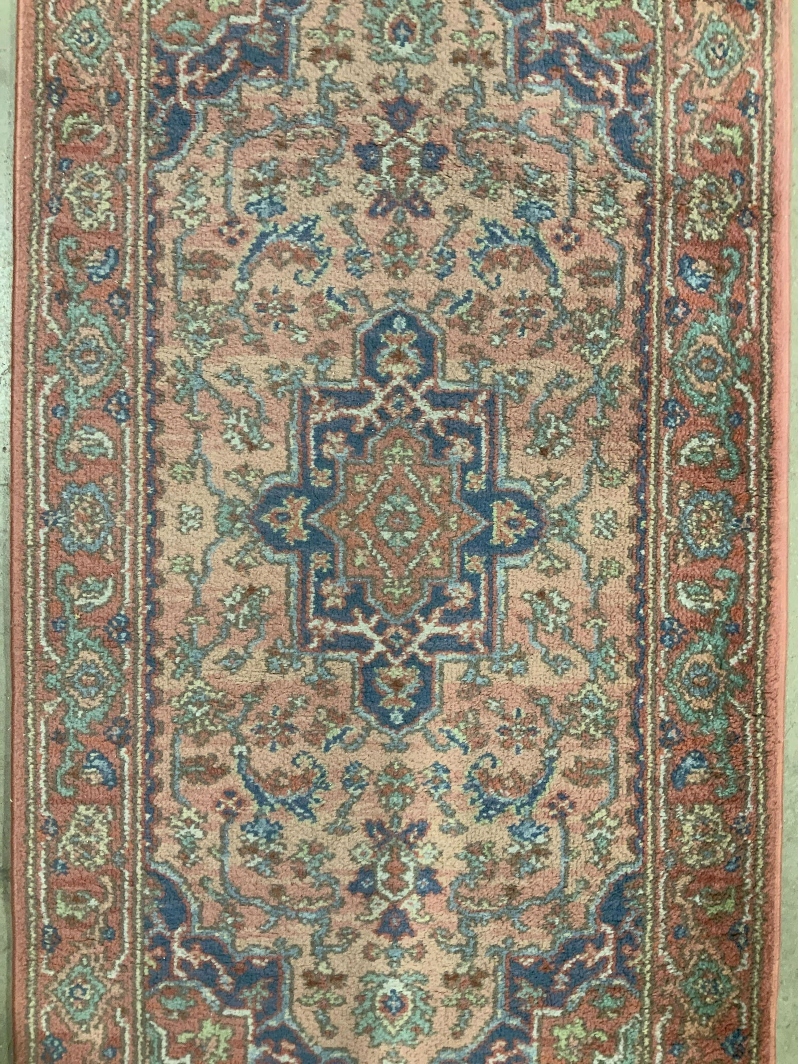 Vintage KARASTAN Wool Rug: Rug is wool. Piece appears to be vintage. Tag on underside reads KARASTAN. Piece has multi toned floral, vine, & geometric detail. Rug is fringed. Possibly hand made, possibly machine made. Piece meas