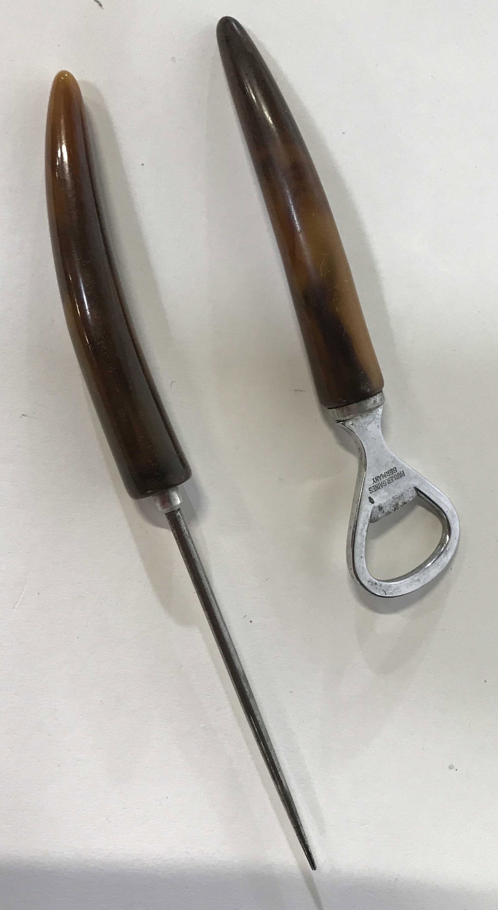 Bar tool set of 2: Bar tool set includes bottle opener and ice pick, handles are tortoise shell style in brown carved smoothly into a tusk shape, inscription on head of bottle opener reads Parker Gains Germany, in the s