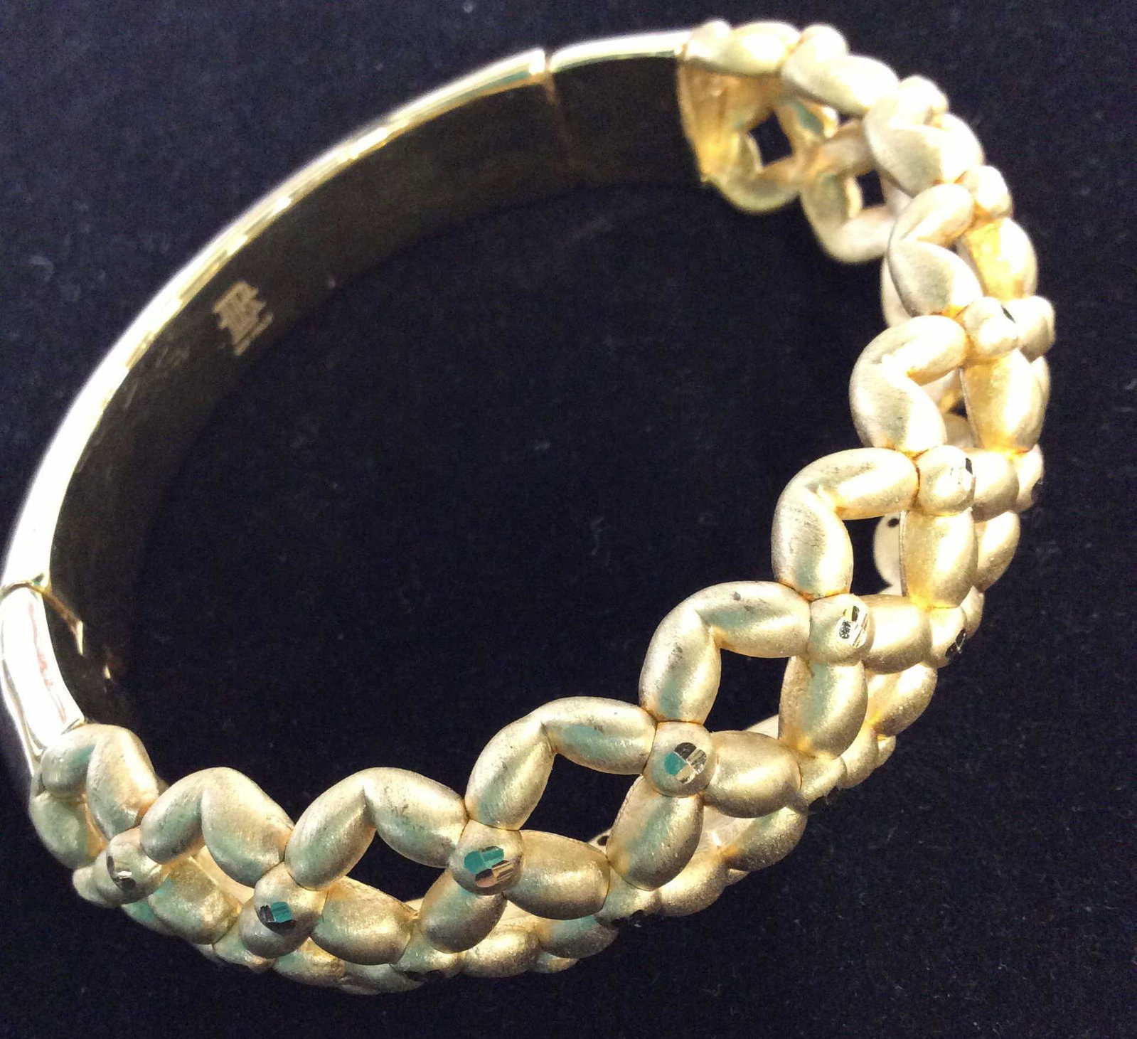Italian Sterling Silver Gld Tn Reticulated Bangle: Oval shape, opening 2.5 in long. Solid bar hinge snaps on / off to put on. Brushed gold tone metal with reticulated pierced basket weave design, specs of glittering polished metal center the patterns.