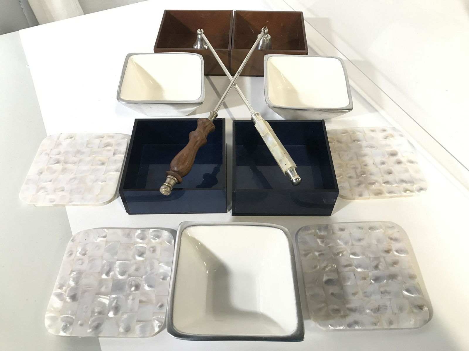 Lot 13 Group Lot Tableware: Lot includes 2 candle snuffer, 4 mother of Pearl coasters, 3 pewter & porcelain condiment dishes 2 blue toned & 2 brown toned trinket boxes. 1 candle snuffer has wooden handle while other has mother o