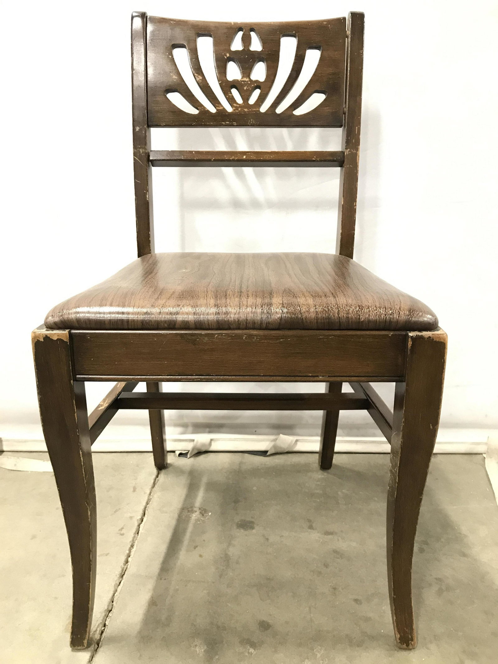 Vintage Carved Wooden Side Chair: Chair is brown toned and wooden. Piece is vintage possibly antique. Top of backrest has carved wooden detail. Piece measures approximately 34 inches tall 18 inches wide 17 inches deep. Vintage chair, 