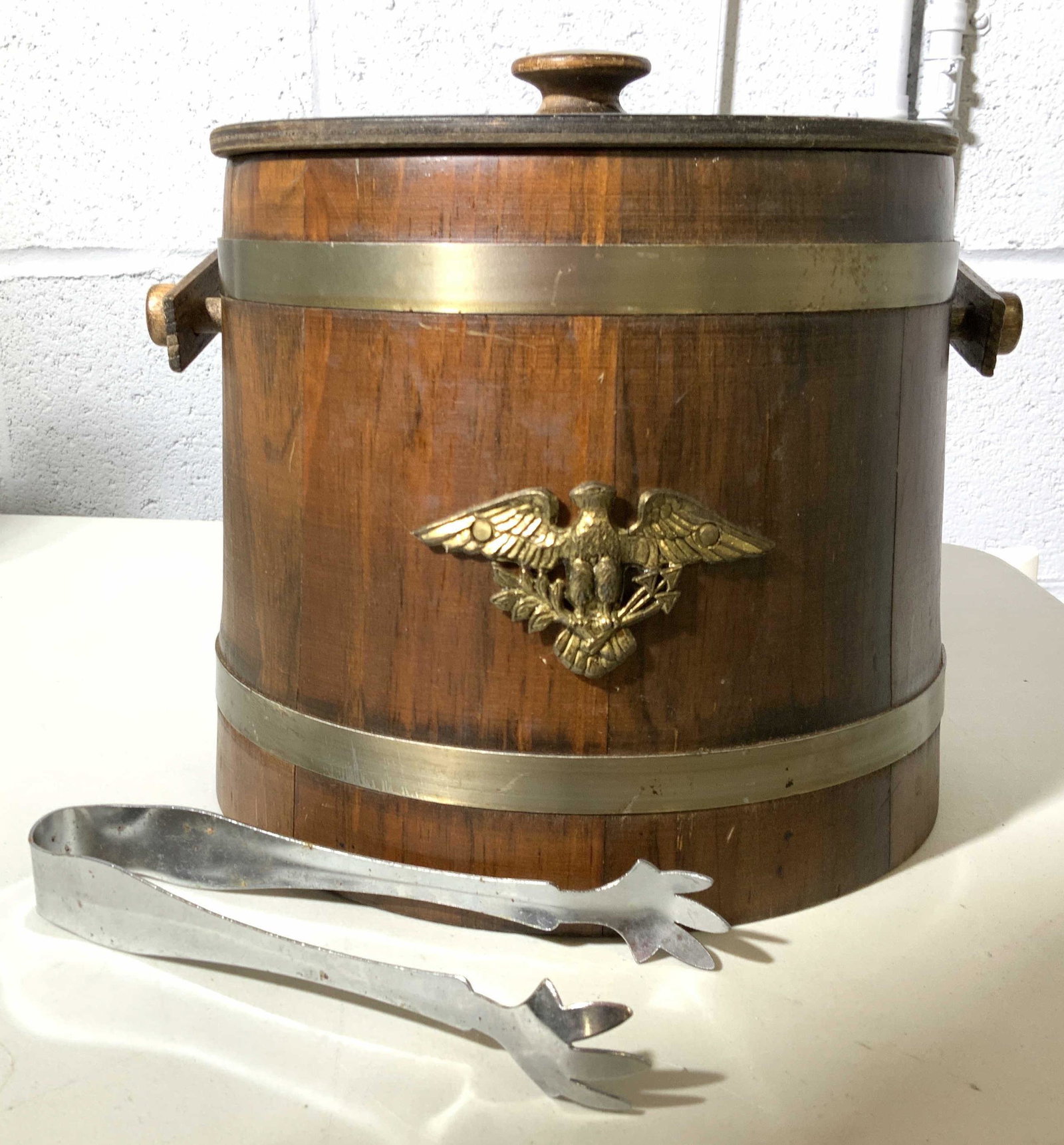 Vintage Wood Brass Ice Bucket w Tongs, Vermont: Wood barrel form ice bucket with brass banding and brass eagle medalian, comes with chrome ice tongs, bucket measures app ht to finial 9 inches diameter app 11 inches, up cycle country decor, vase, ve