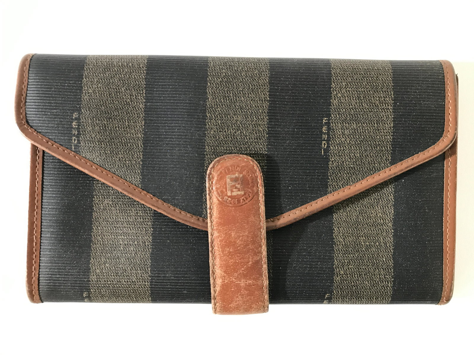 FENDI ROMA Clutch: Interior of clutch has gold toned marking which reads FENDI ROMA MADE IN ITALY. Piece has 4 sections in addition to zippered area, card holder area, identification holder area & extra pocket. Piece ha