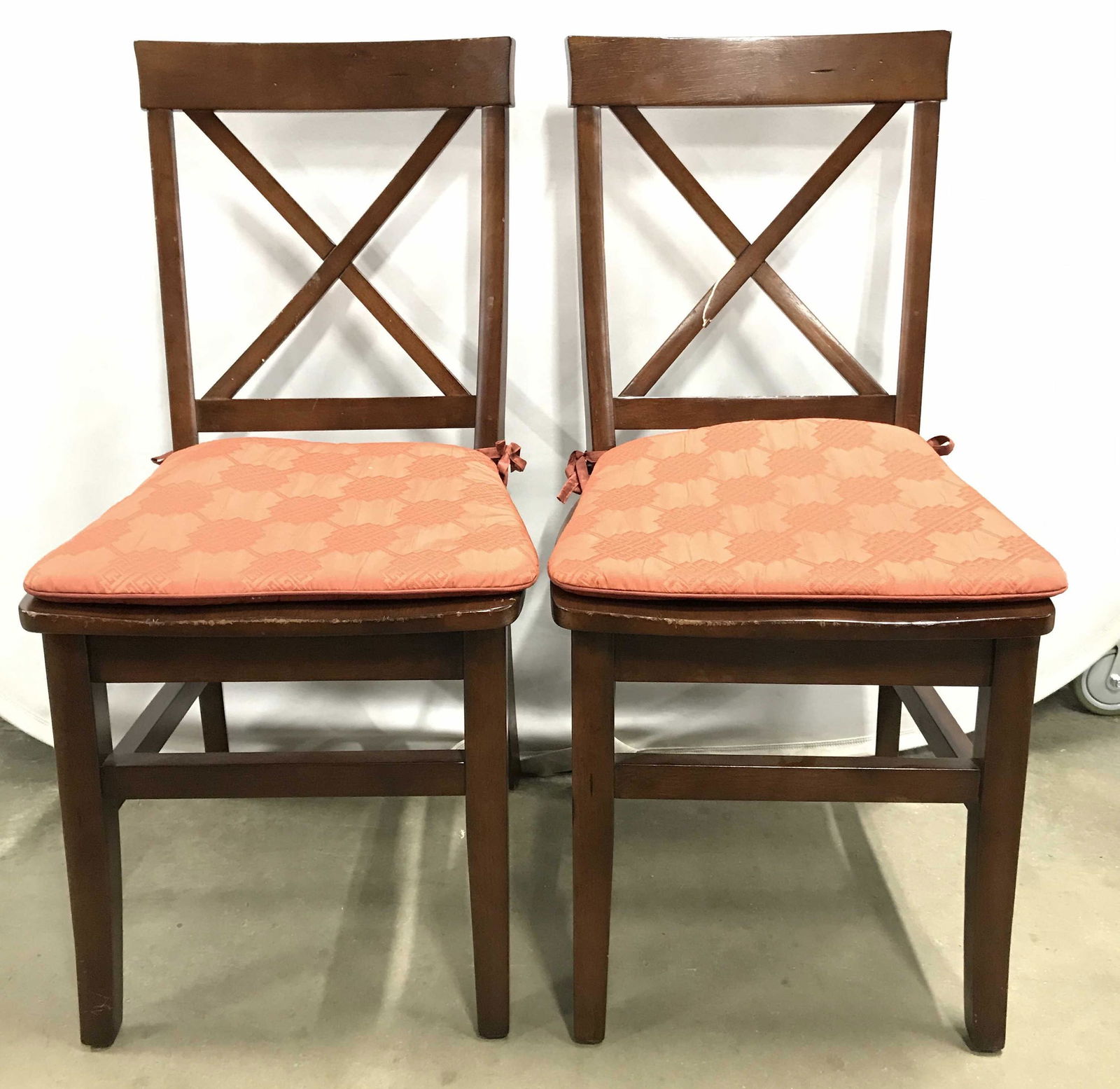 Pair PIER 1 Carved Wooden Side Chairs: Underside of each chair has tag which reads PIER 1 IMPORTS. Chairs are wooden. Each have X shaped backrest. Chairs have stretchers between legs. Side chairs, dining chairs, wooden chairs, wooden side