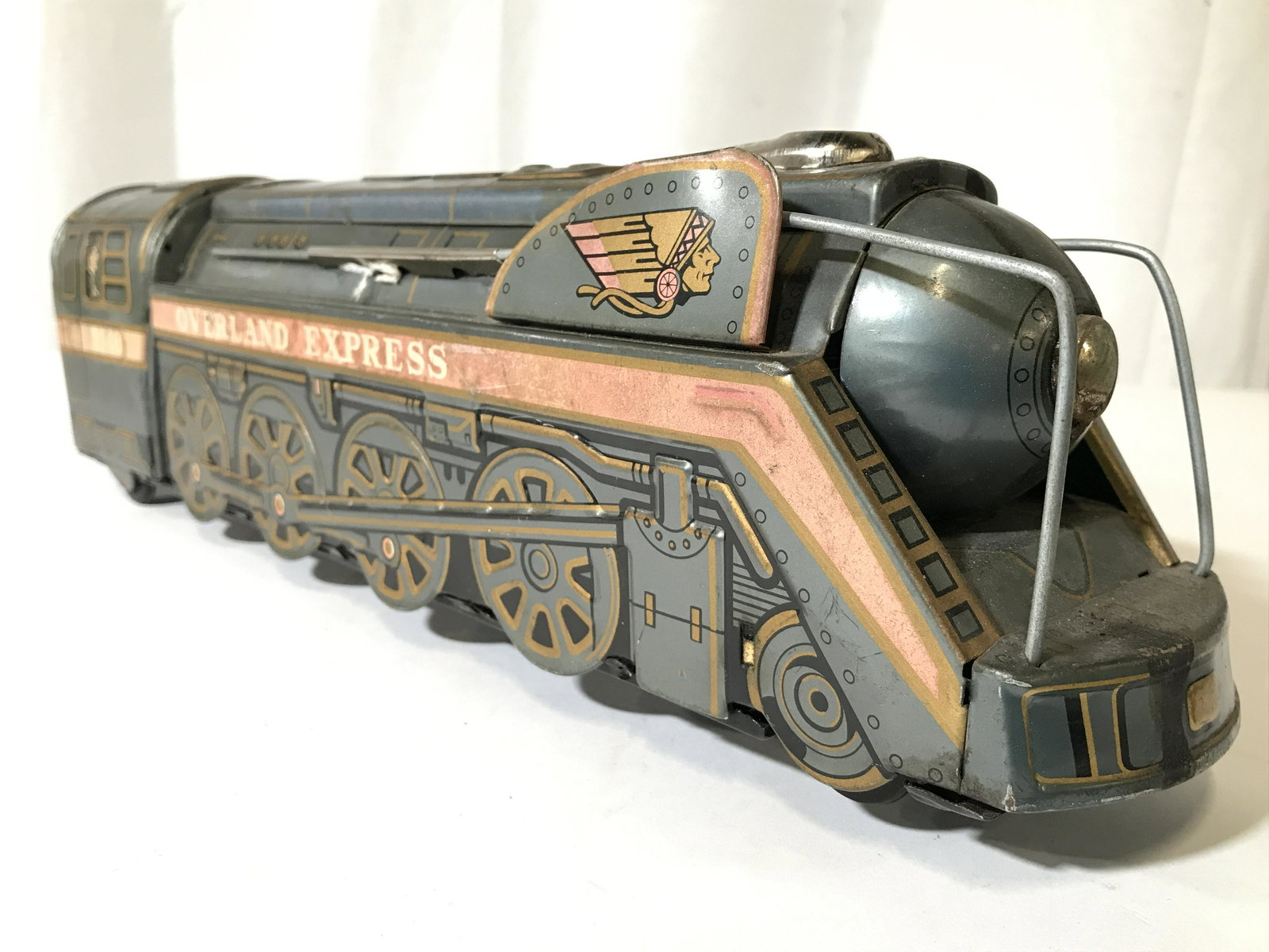 MODERN TOYS Vintage Metal Toy Train: Tag on piece reads MODERN TOYS. Piece is silver toned with painted detail depicting train conductor, and name of train OVERLAND EXPRESS 3140. Piece measures approximately 16 inches long 4.5 inches tal