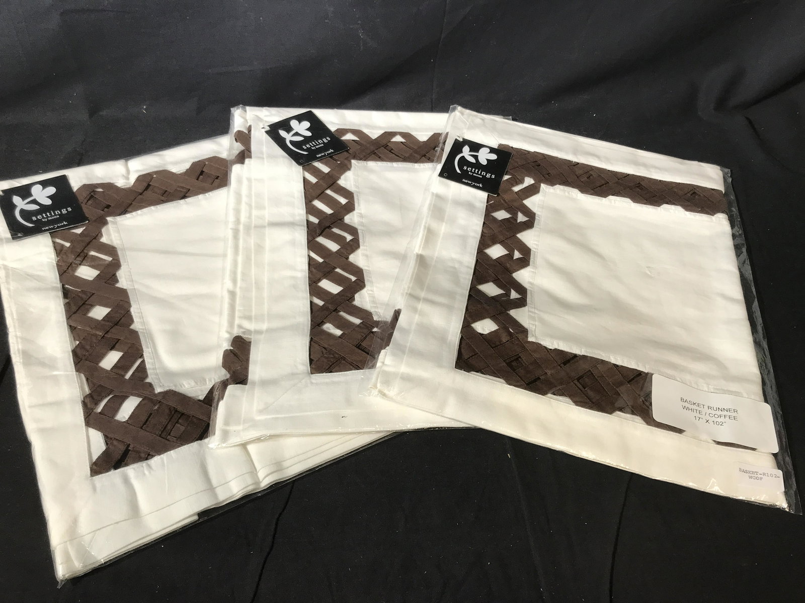 Set of 3 Basket Weave Table Runners: New table linens in original sealed packaging, Set of 3 basket weave table runners, label to bag reads ‘Basket Runner White/Coffee 17’ x 71’ ‘, label to bag reads ‘Basket-r71-wcof’, tag to