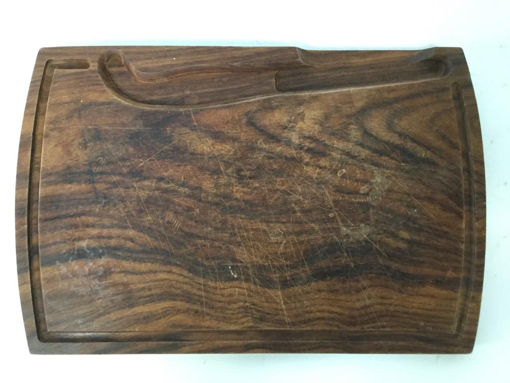 Vintage Carved Wooden Cheeseboard: Cheeseboard is brown toned and wooden. Piece has area carved out for cheese knife. Cheese board, wooden cheese board, tableware vintage cheese, carved wooden cheese board. Piece measures approx 14 inc