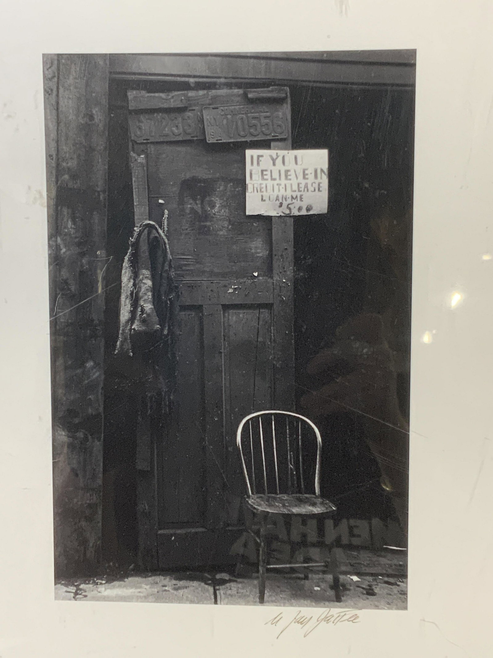 Signed N Jay Jaffee Black and White Photograph: vintage, Black and White Photograph, signed by the artist, depicting a chair in a run down doorway with a sign that reads: if you believe in credit- lease lone me $5.00, framed in shadow box type clea