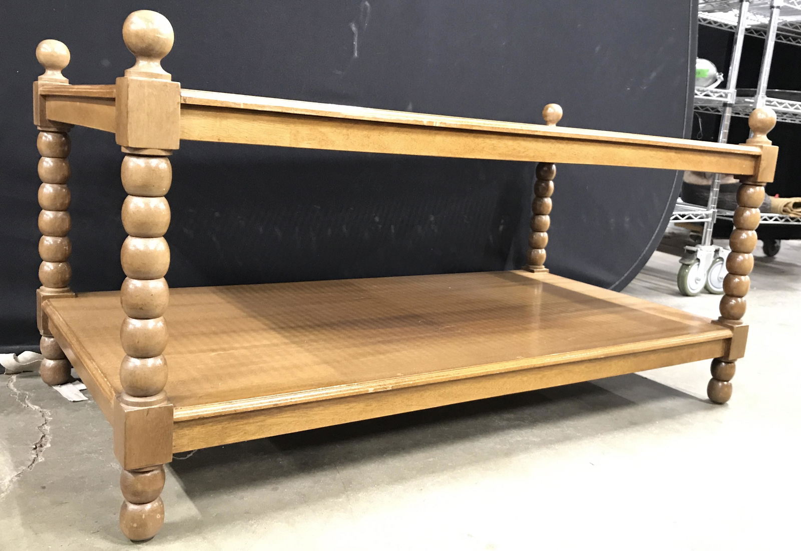 Vintage Carved Wooden Caned Glass Top Coffee Table: Coffee table is vintage. Piece has carved wooden legs with spherical shaped finial style structures at corners, bobbin style, Table has 1 wooden tier Under table top. Which is caned with glass overlay