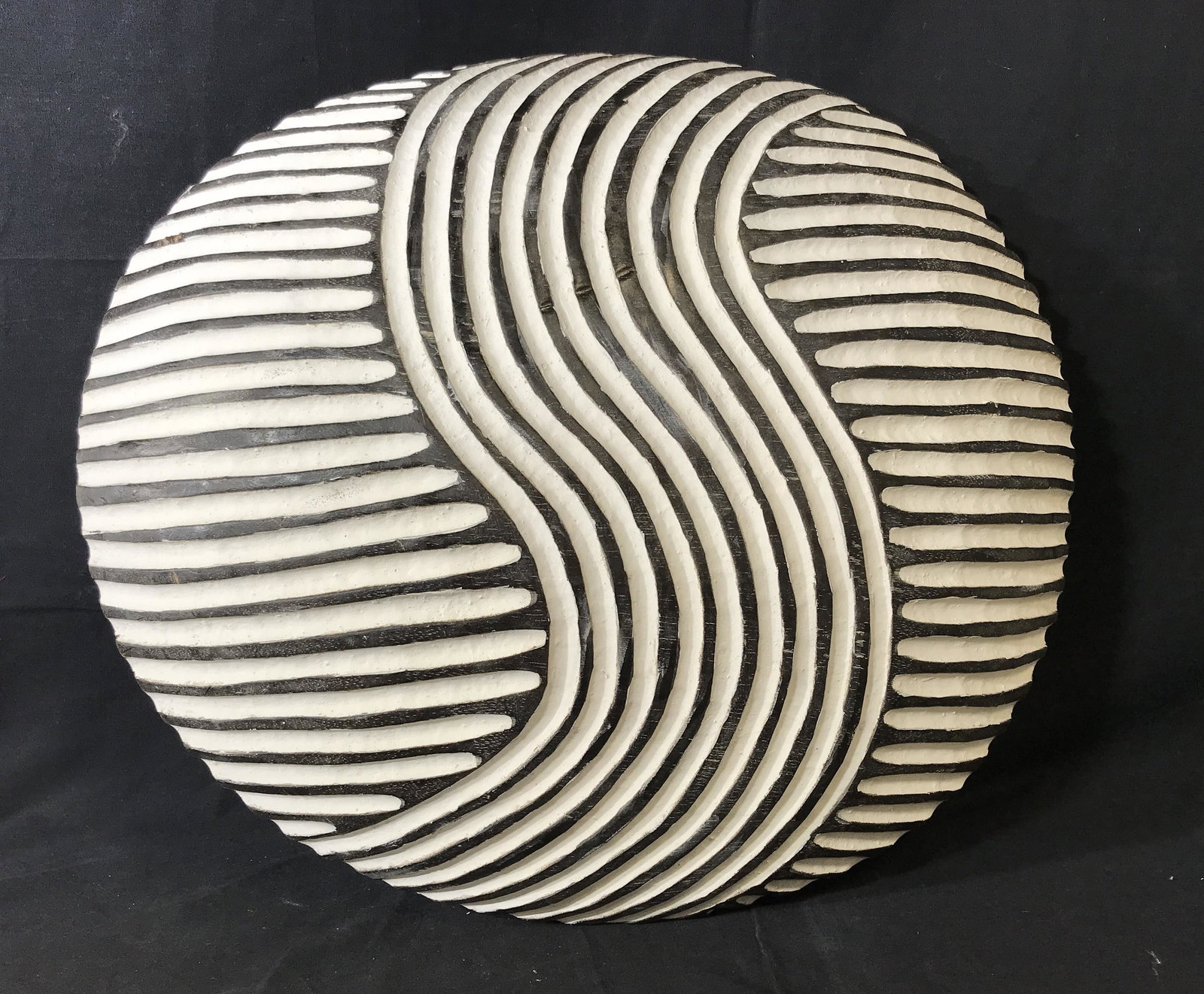 Ceremonial Zulu Shield: Ceremonial Zulu Shield, origins can be found in South Africa, wooden shield with black and white paint, handle carved into the back, diameter approximately 20.5 inches wide, some scratches to front sh