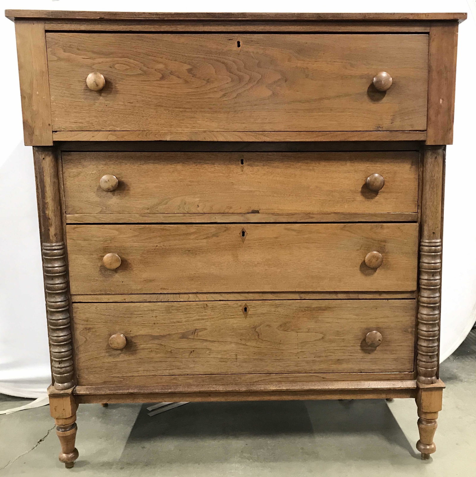 Carved Wooden Antique Tall Boy Dresser: Dresser is vintage possibly antique. Piece appears to be hand carved in certain areas. Drawers have hand dovetailing. Dresser has 4 drawers each with carved wooden knob style handles. Piece measures a