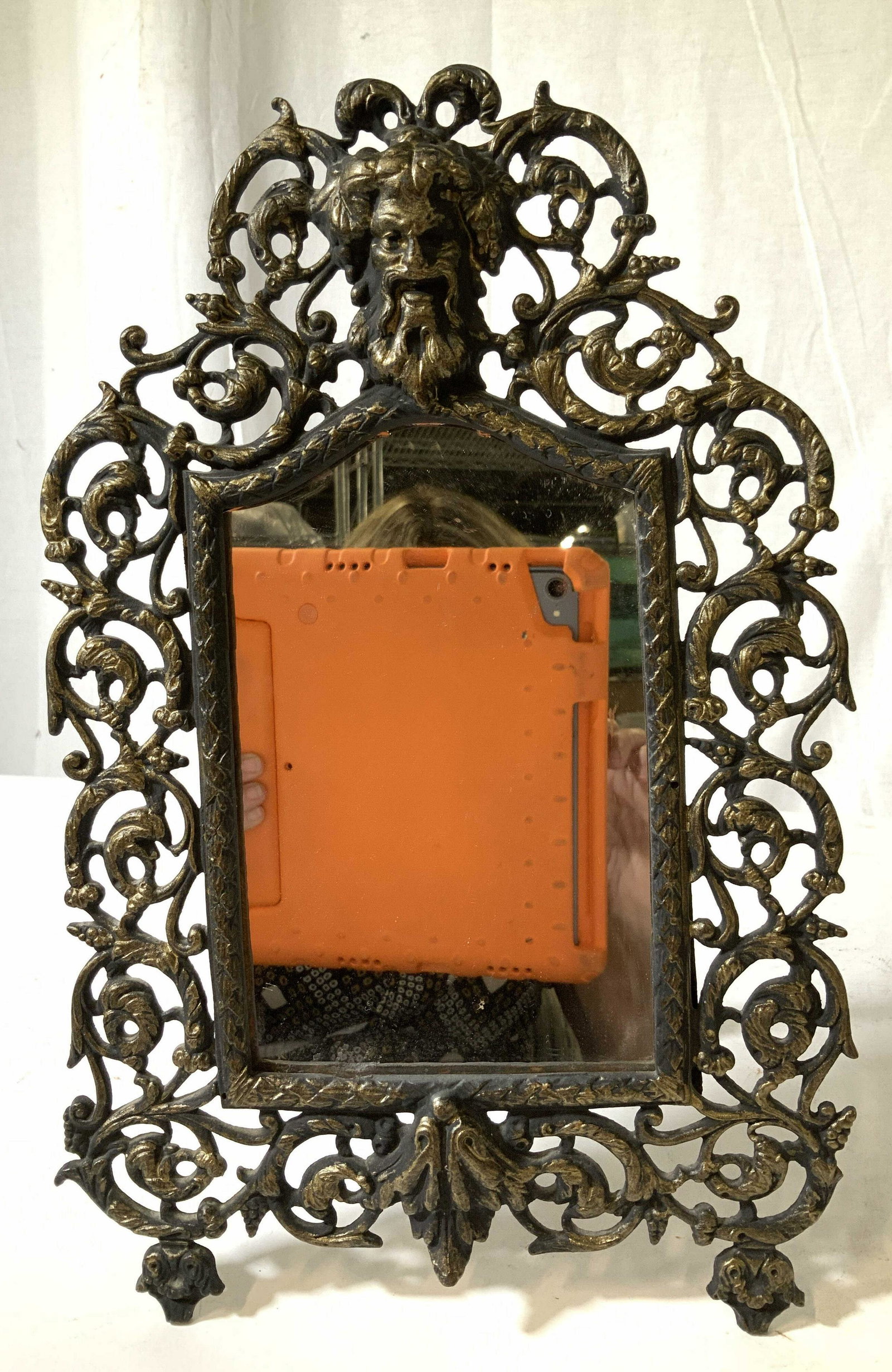 Antique Victorian Gilded Metal Dresser Mirror: Gilded metal iron or bronze frame ornately scrolled openwork with gargoyle face relief as center medallion, stand on feet and easel form stand, Victorian mirror, dresser mirror, decorative arts, antiq