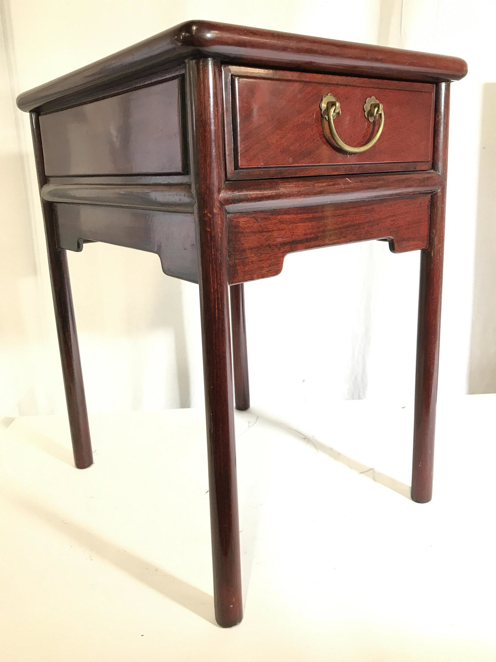 Vintage Chinese Carved Wooden Side Table: Side table is vintage. Piece appears to possibly be mahogany or cherry. Side table contains 1 drawer. Drawer has hand dovetailing. Drawer handle is gold toned and appears to be brass. Table has 4 legs