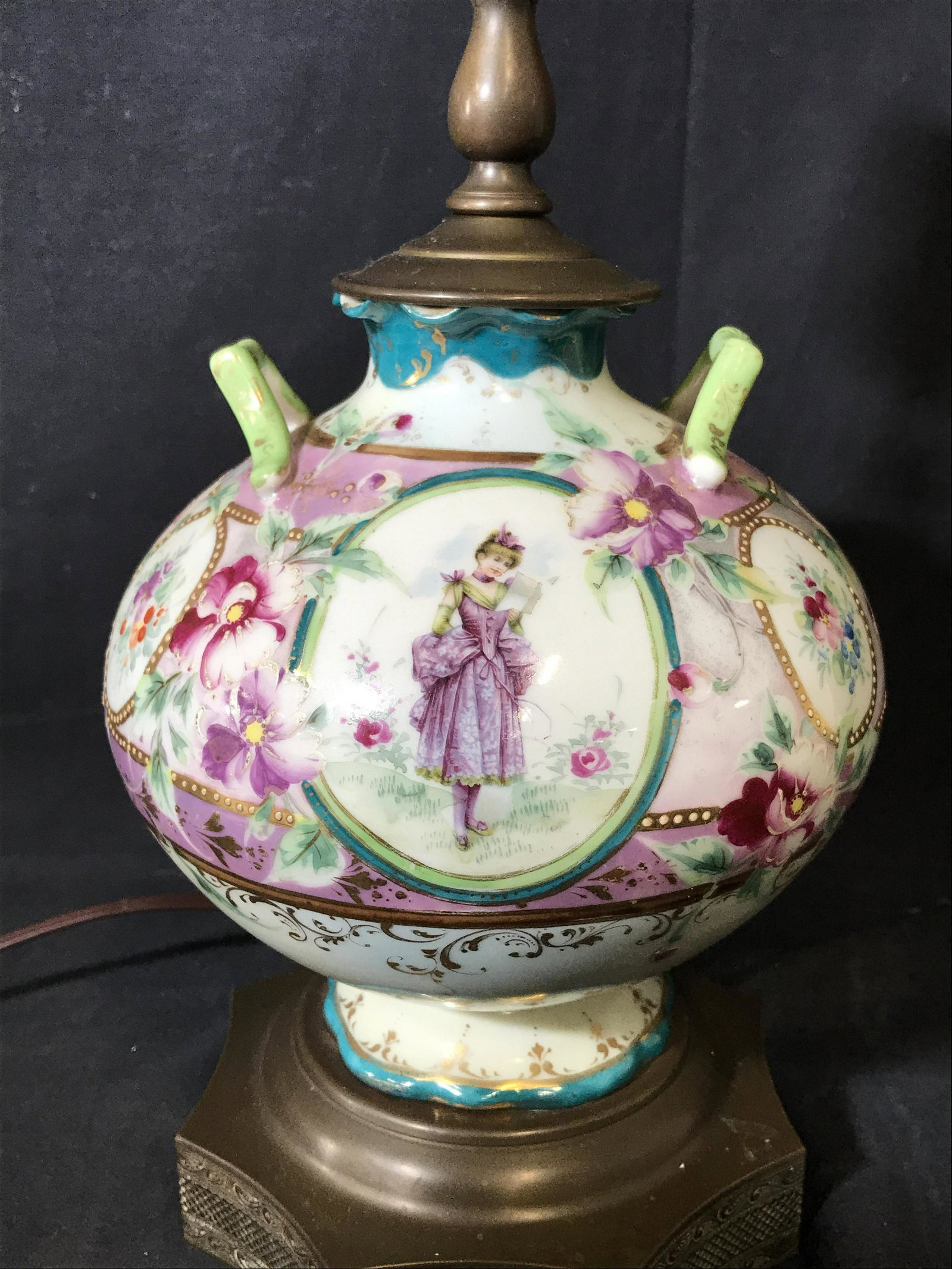 Rococo Porcelain & Bronze Lamp: Rococo Porcelain and bronze lamp, base of lamp is made of finely detailed bronze, shaft of lamp is a porcelain vase hand painted with rococo scenes and flowers, top piece to lamp shows a hand grasping