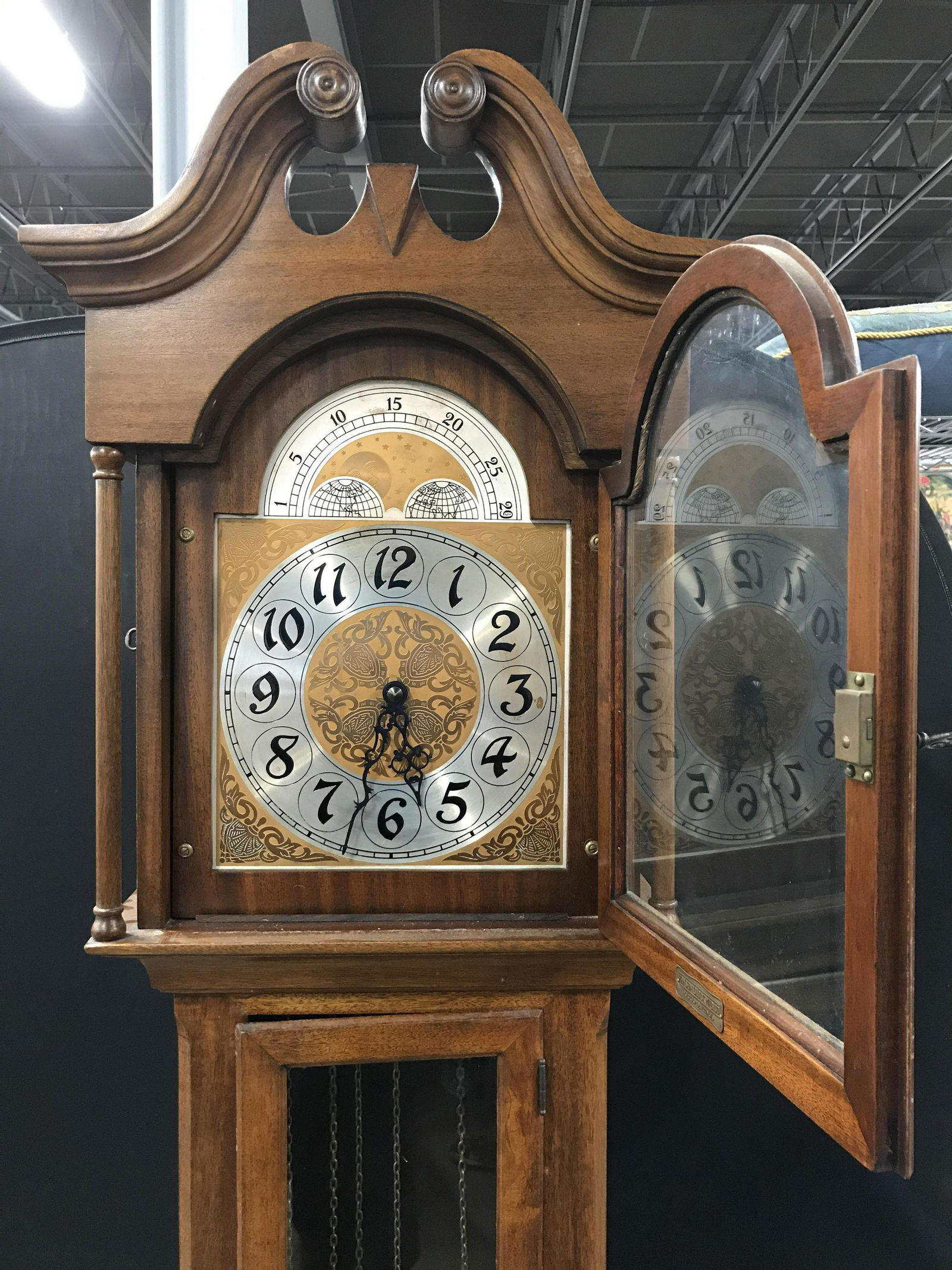 Vintage Carved Wooden Grandfather Clock: Tag on interior of clock face window reads HANSON CLOCK MFG CO. Lot includes clock, 3 clock weights and pendulum, Piece measures approximately 83 inches tall 18 inches wide 12 inches deep. Sides of cl