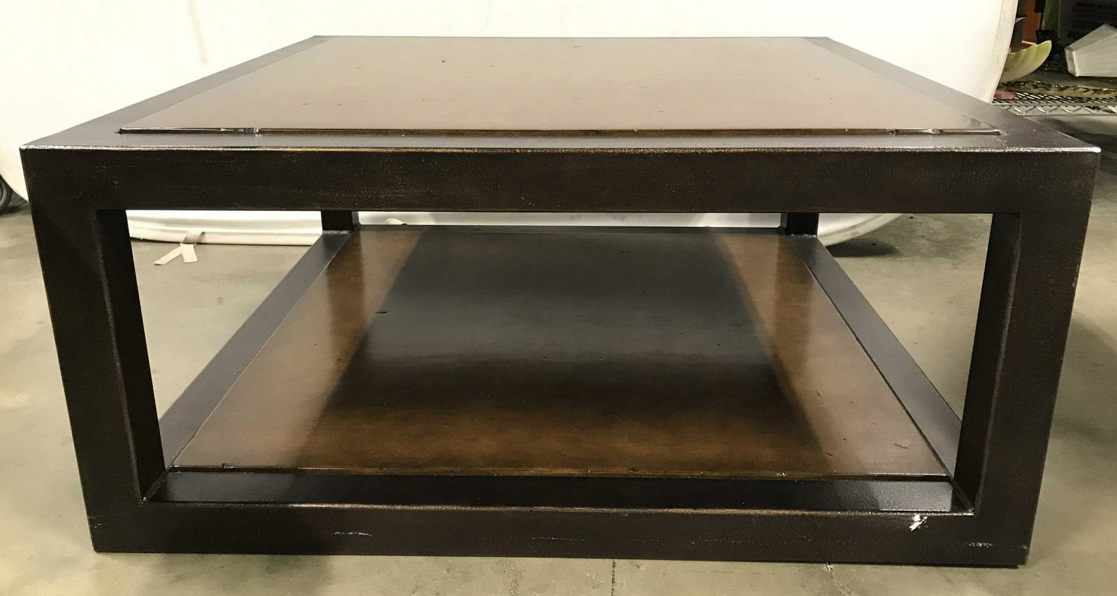 Metal & Wood Square Coffee Table: Coffee table has square shape. Frame of coffee table is metal. Tabletop insert and lower insert appears to be wooden. Piece is light & dark brown toned. Coffee table, square coffee table, metal coffee