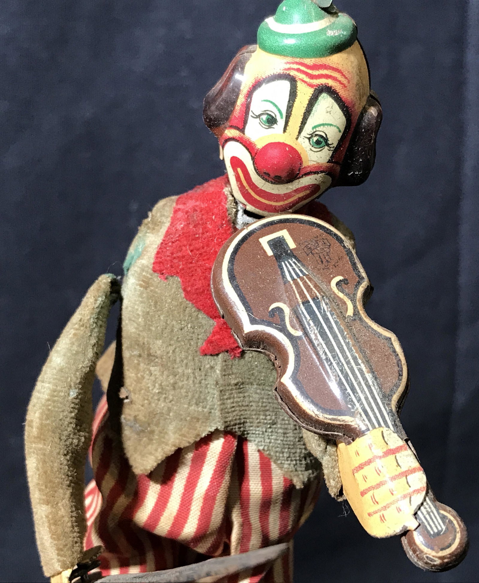 Vintage Wind Up Clown Doll: Vintage possibly antique wind up clown doll, clown is playing a fiddle, doll is wearing yellow and red striped pants and a brown and red jacket with a greet bowler hat, when the key on its back is twi