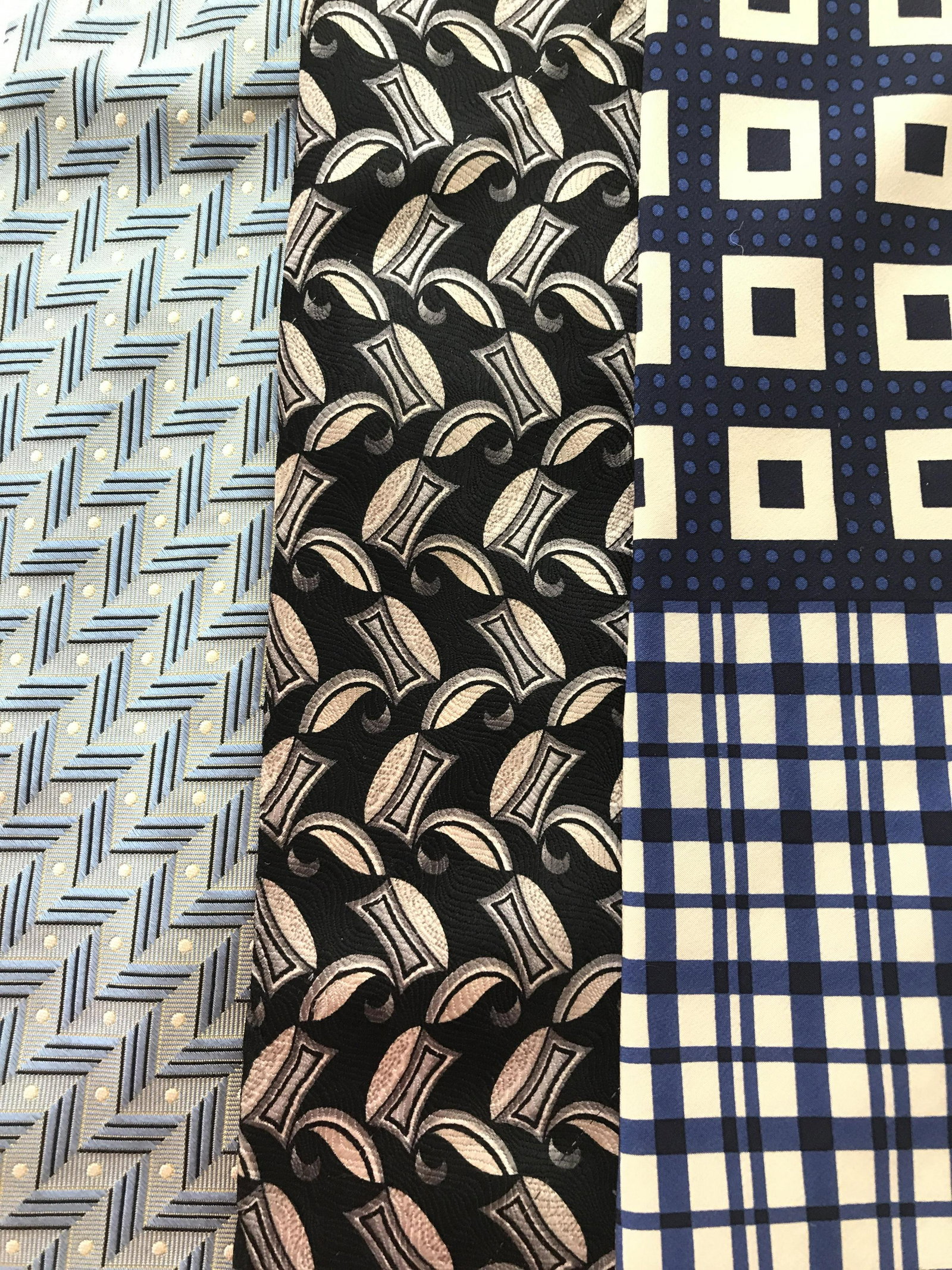 Lot 3 Vintage Neckties: Three vintage, men’s ties. The ties feature varying designs and manufacturers. Labels read HUGO BOSS, COMO COLLEZIONE, and BRANDINI. The longest tie measures approx 57.5 inches Long, and 3.75 inches