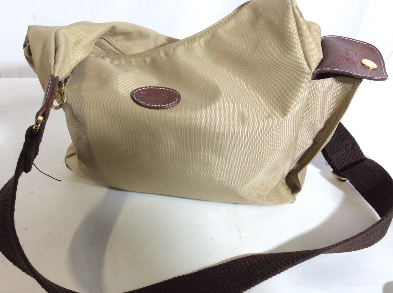 Authentic Vintage LONGCHAMP Canvas Style Bag: Beige nylon Longchamp bag, silimar to Le Pliage tote, Signed Longchamp in gold-tone zipper hardware, and impressed Symbol on leather pocket flap. Dual flat cotton handle straps, brown pebbled leather