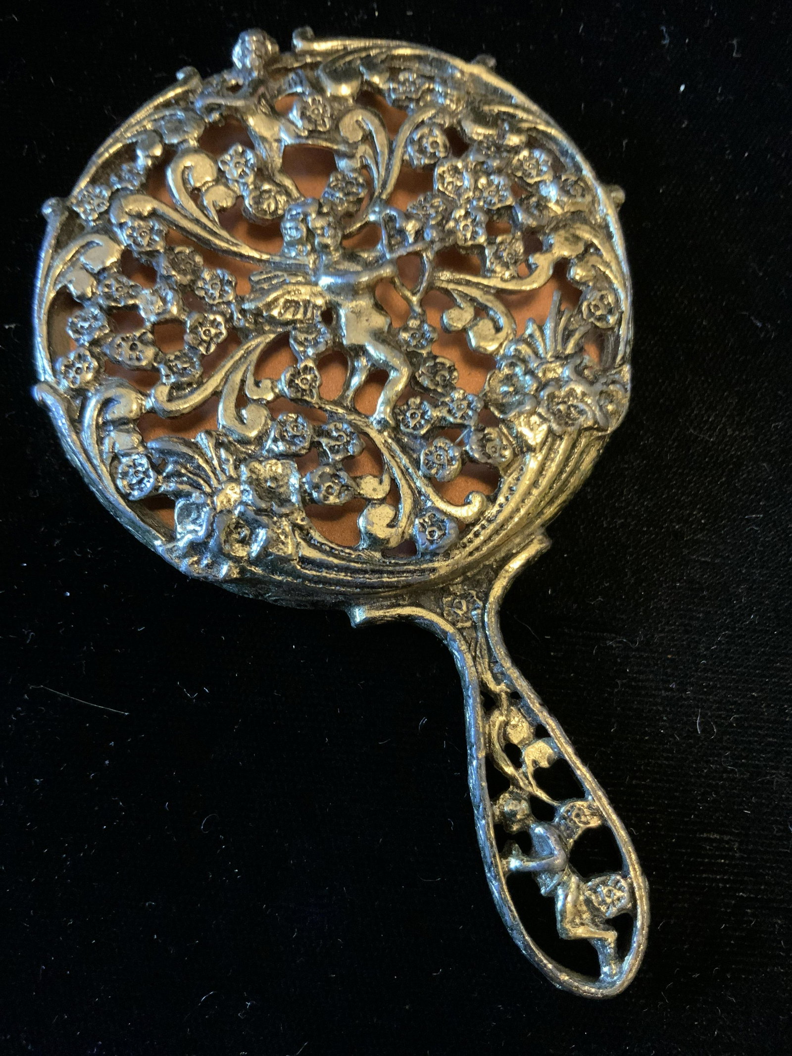 Art Nouveau Hand Held Mirror w Cerubs: Dresser mirror, vanity mirror, dresser top accessory, filigreed gold toned design with frolicking Cupid’s, puttis, angels, cherubs among sinuous scrolled vines. Mirror measures app 4.25 inches lengt