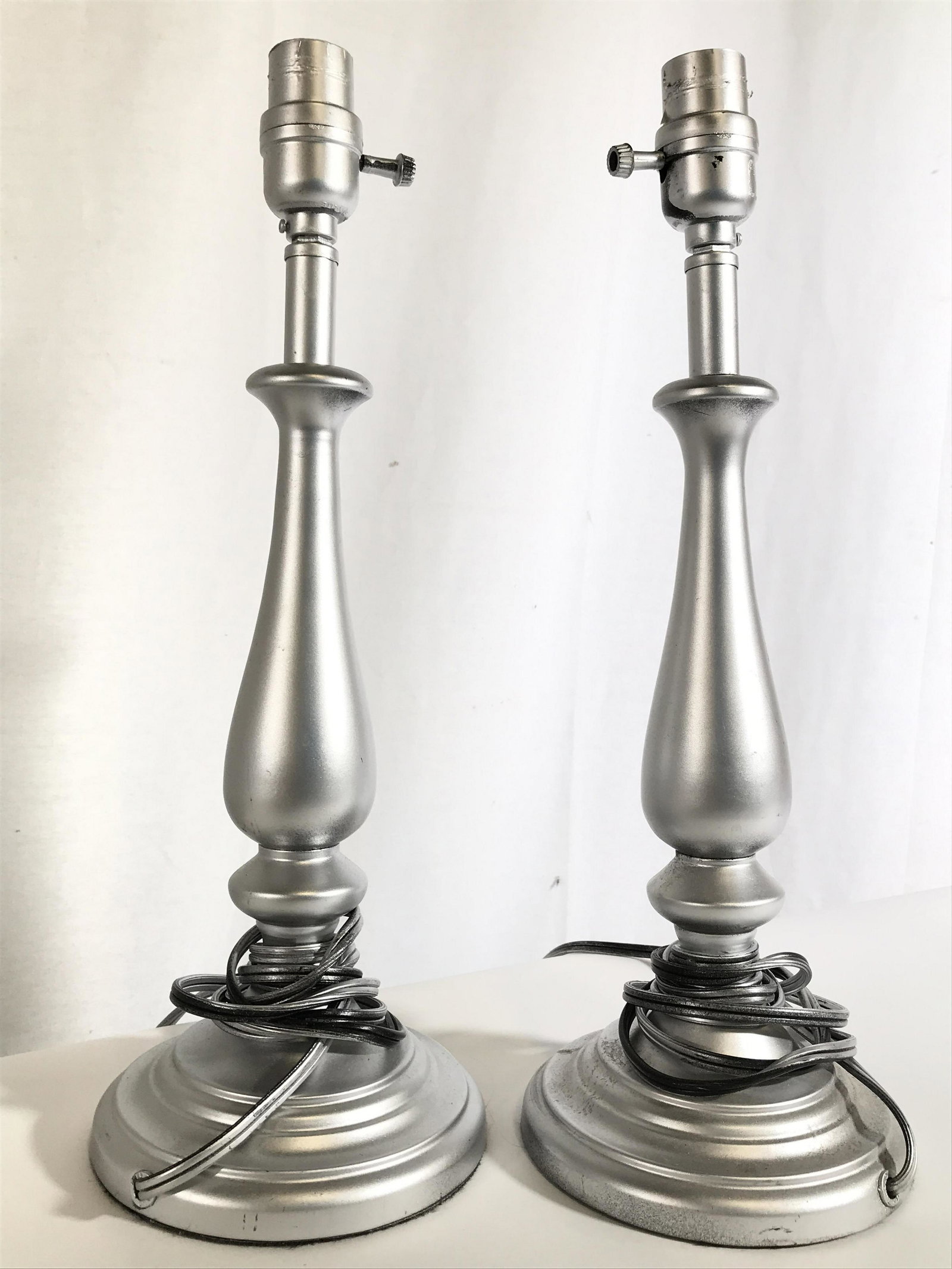 Pair Silver Toned Metal Table Lamps: Lamps are silver toned and metal. Each lamp have round base. Table lamps, lamp, metal lamps, decorative arts, side tale lamps, home lighting and decor, end table lamps. Each measures approximately 16.