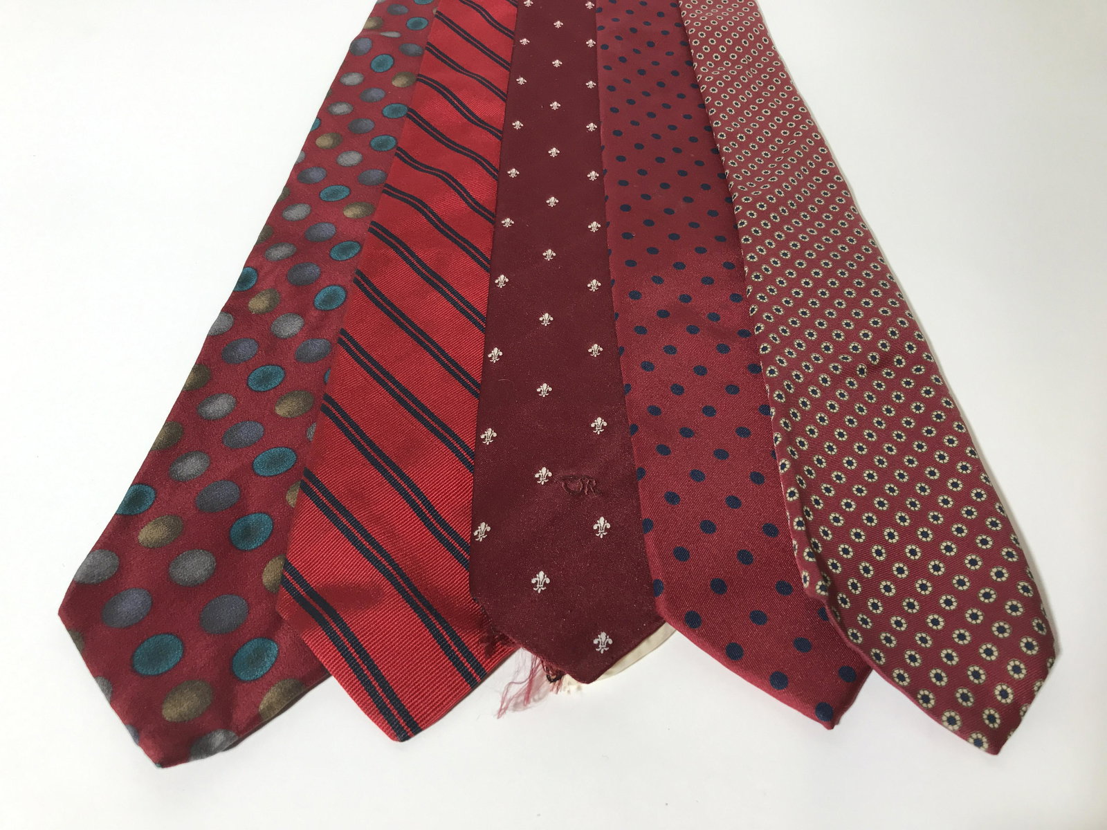 Lot 5 Vintage Red Toned Men’s Neckties: Lot 5 vintage ties. The ties are varying tones, patterns, each tie is from a different designer. Designer labels include: COLOURS BY ALEXANDER JULIAN, BROOKS BROTHERS, BANCROFT LTD, ROBERT TALBOTT, an
