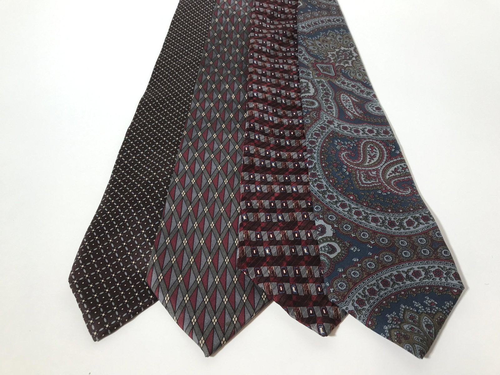 Lot 4 Vintage Men’s Neckties: Lot 4 vintage ties. The ties are varying tones, and patterns, each tie is from a different designer. Designer labels include: PIERRE BALMAN, ALFANI, CHRISTIAN DIOR, and HASTINGS TRADITIONS. Hastings T