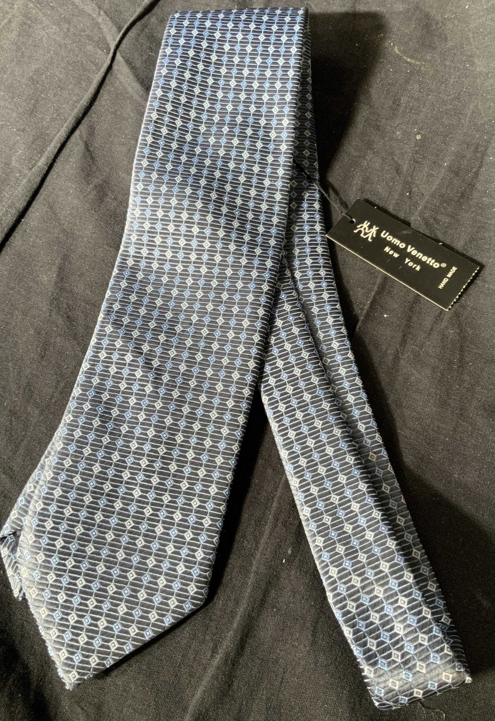 Vintage Uomo Venetto Handmade Tie: Labels read Uomo Venetto handmade, Vintage tie in blues and blacks, ornate, highly detailed small pattern, varying diamonds in medium and sky blue on a navy background, lightly textured silk, handmade