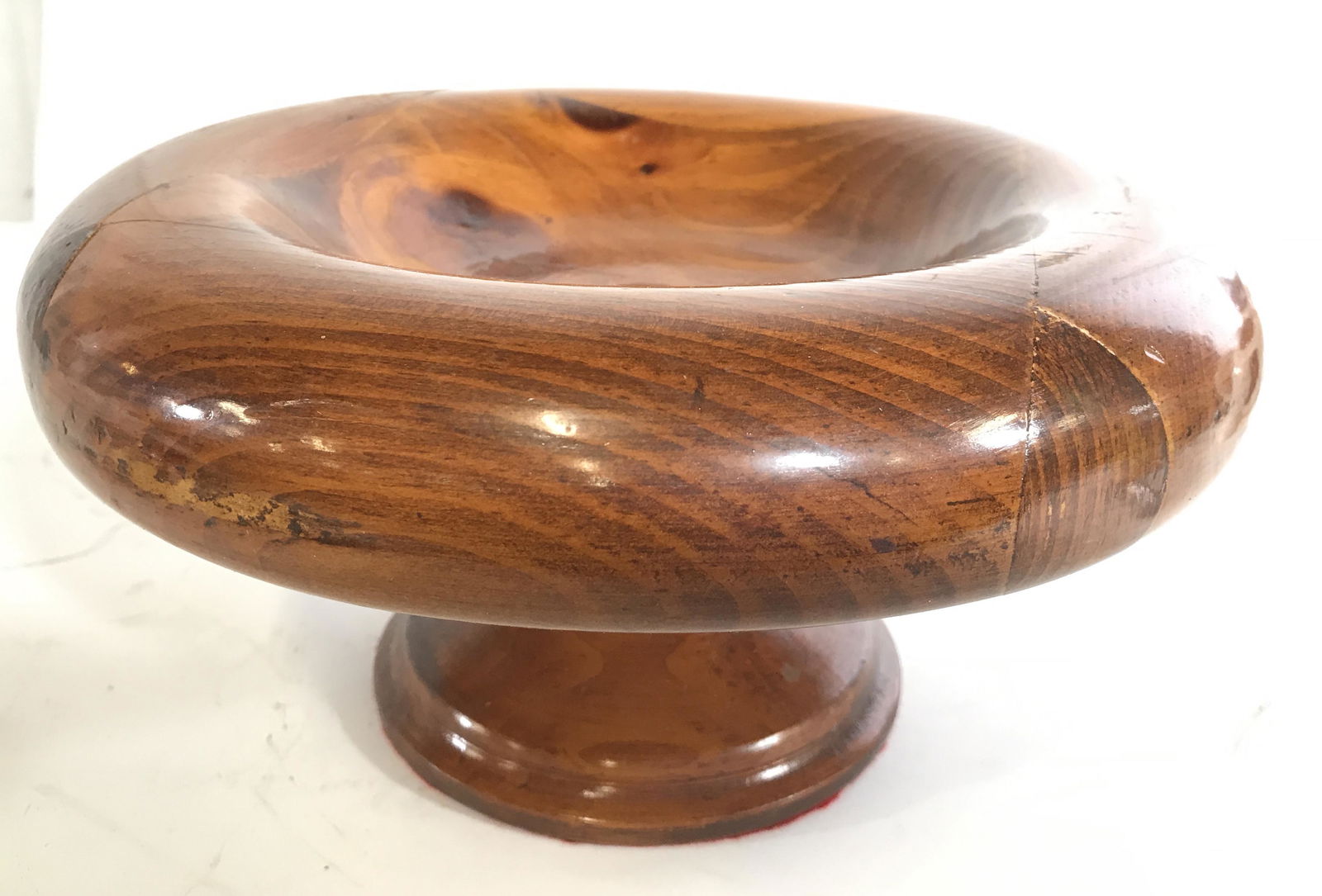 Low Pedestal Footed Carved Wooden Candle Holder: Candle holder is wooden. Piece is possibly hand carved. Piece appears to be a candle holder, up cycled candy dish, up cycled centerpiece. Piece measures approximately 10 inches wide 5.5 inches tall. C