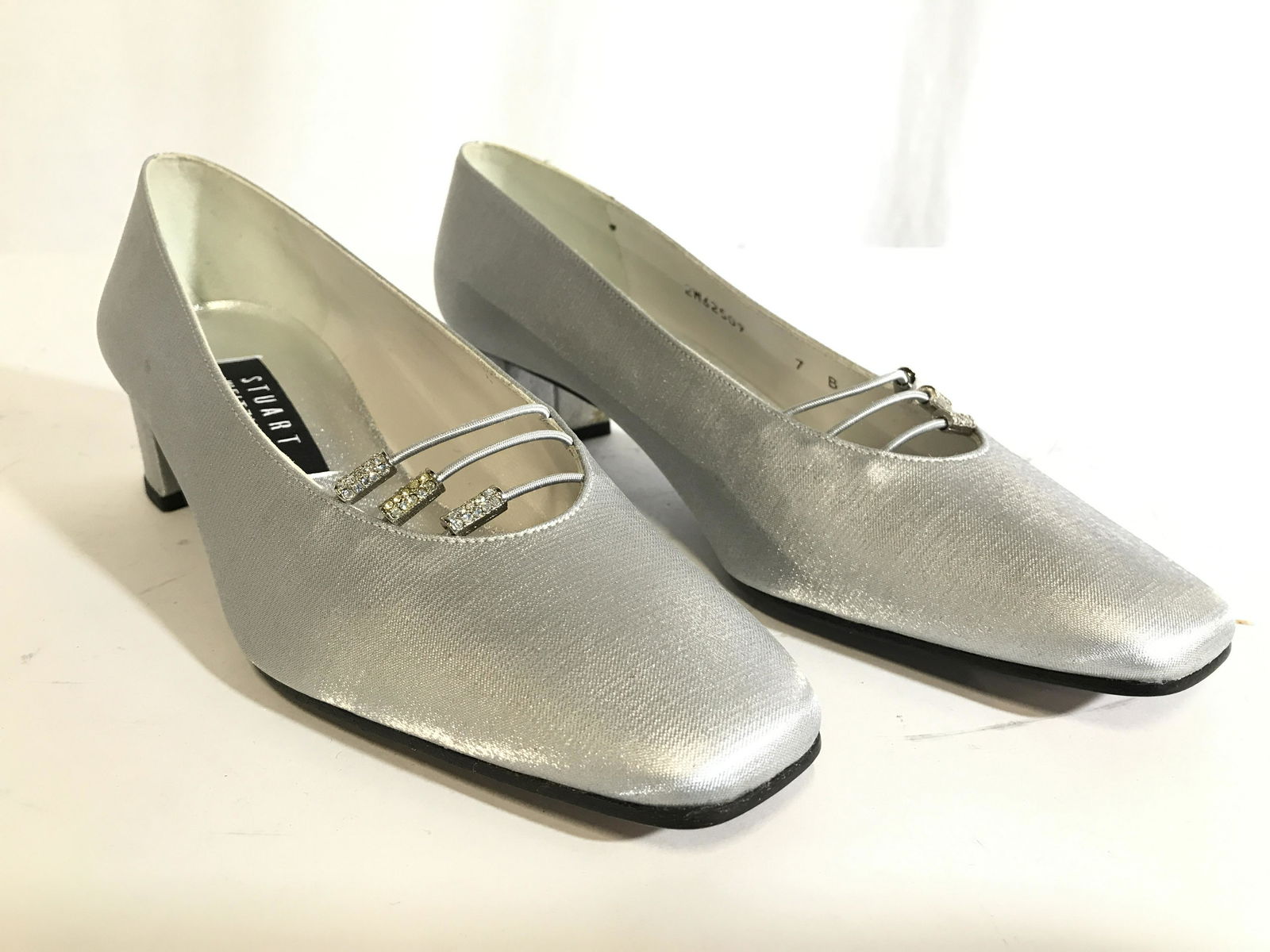 STUART WEITZMAN Women’s Heels Size 7: Sole of sole has label which reads STUART WEITZMAN. Shoes are silver toned. Each have rhinestone shoe ornaments. Underside reads leather sole. Underside is also marked MADE IN SPAIN. SHOES INCLUDE ori