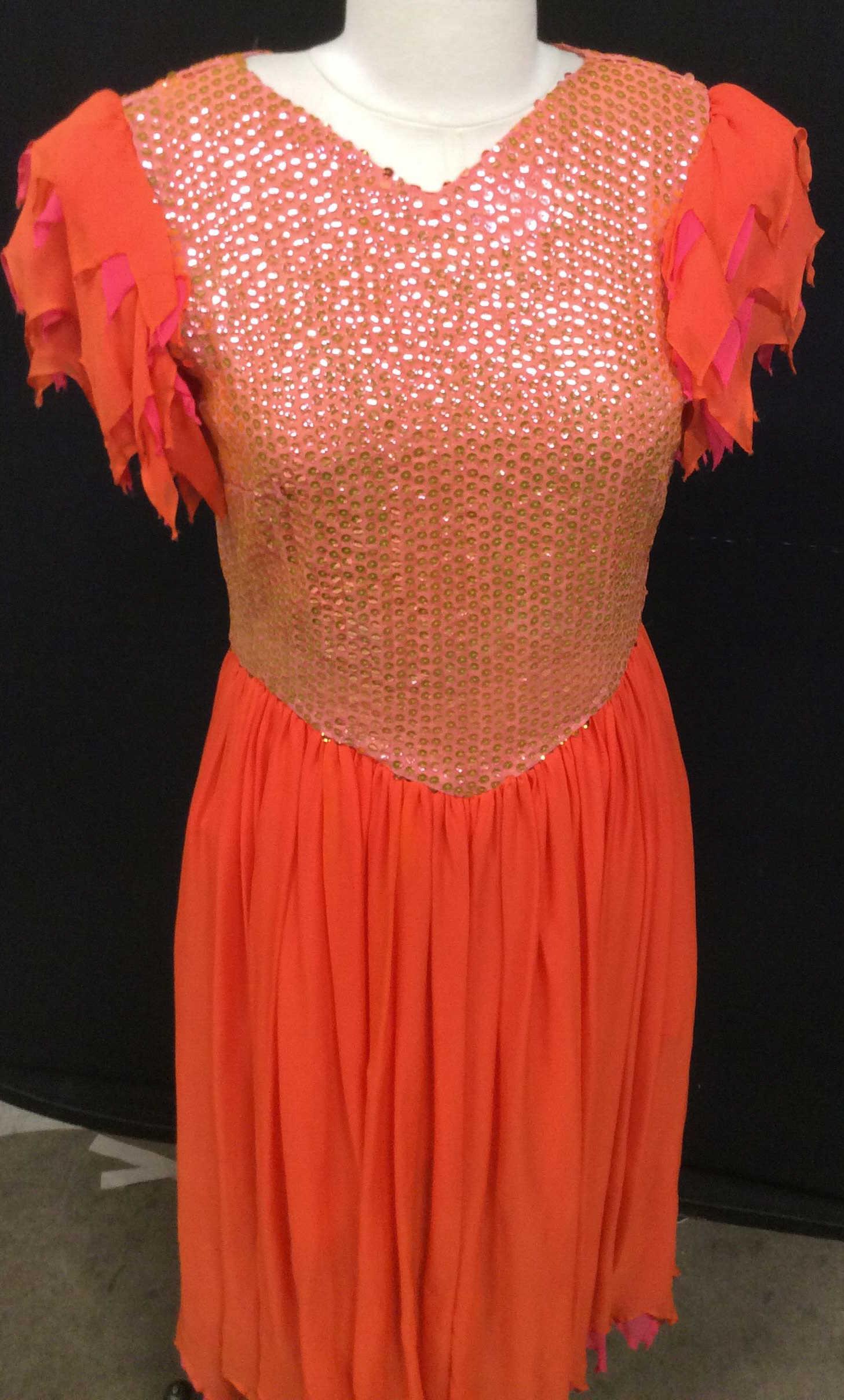 Vintage Sequin Princess ‘Mermaid’ Fashion Dress: Bright orange with pink Sequin body, layered short sleeves, Princess waist app 28 in. Zipper back is attached to slip lining. Zipper is smooth. Dress skirt all sheer silk. 46 in long. A couple of Slig