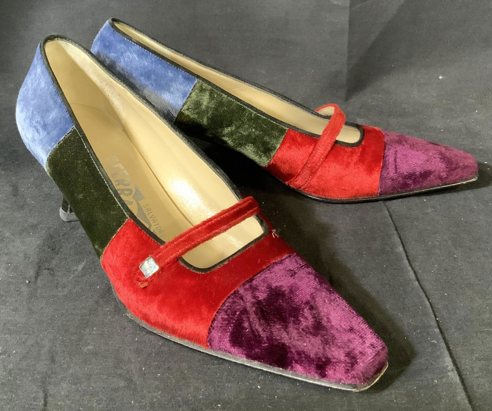 Pair of Vintage Ferragamo Pumps: Pair of vintage Ferragamo pumps with for large swatches fo color, pointed toe, and cross strap, the exterior of the shoes are velvet, the toes are purple, the ball of the foot is red, the arch of the