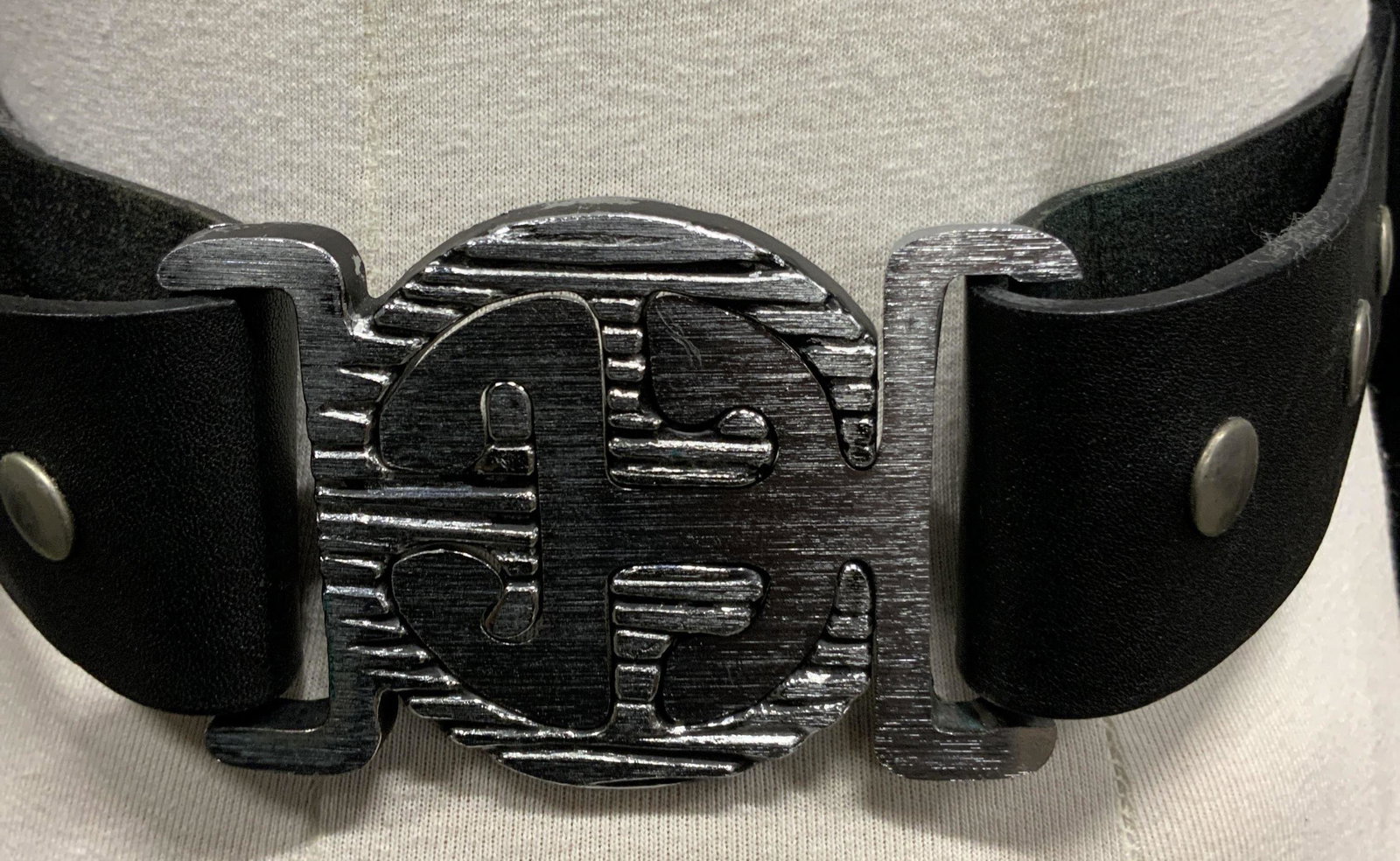 Lot 2 Vintage Fashion Belts: Two vintage belts, one unlabelled that is made of metal and elastic decorated with abstract fan like shapes with scalloped edges fitting together to make a scale like, serpent aesthetic, The enclosure