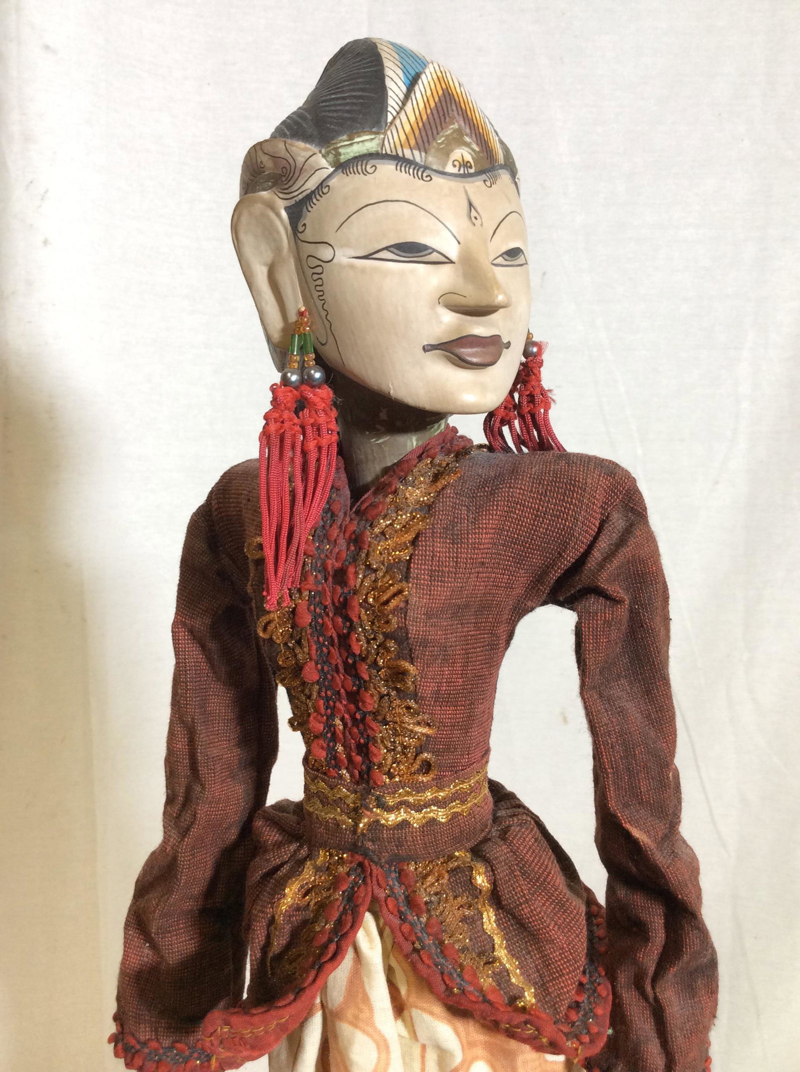 Mixed Media Puppet Woman in Long Dress: Puppet with carved wooden hands, face appears to be wood with heavy finish, possibly composite material, painted face, earrings made of woven thread and beads, dress and shirt, surface wear to wood, d