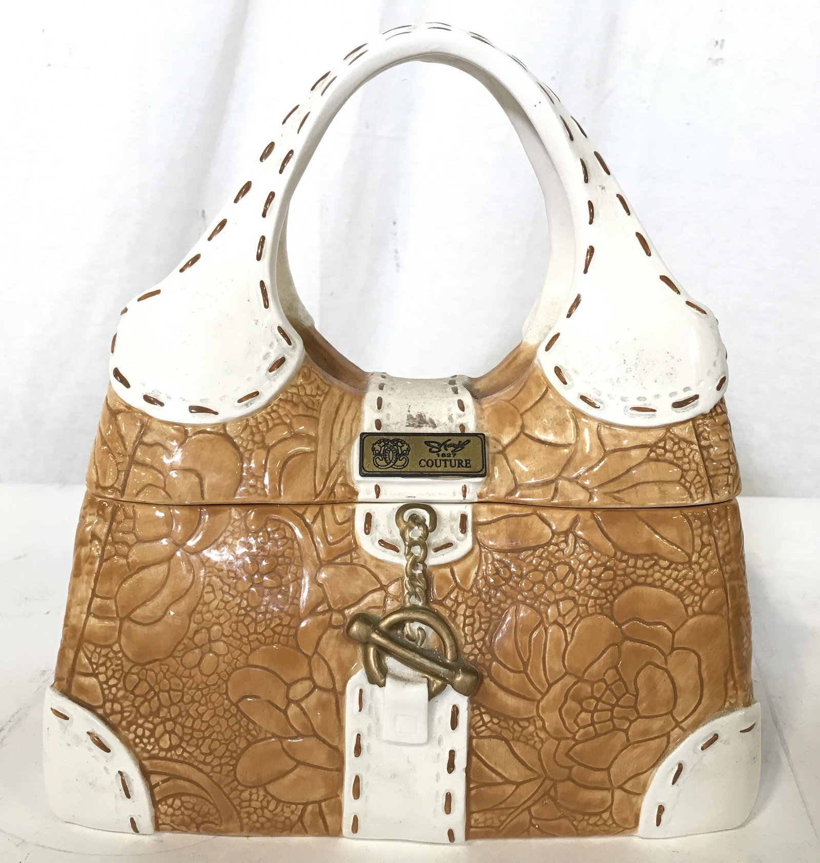 DAVID COOKIES Porcelain Purse Cookie Jar: Underside of piece is marked DAVIDS COOKIES. Cookie jar has shape of purse. Jar has lid with handles piece measures approximately 10 inches tall 9 inches wide, 6 inches deep. Cookie jar, porcelain coo