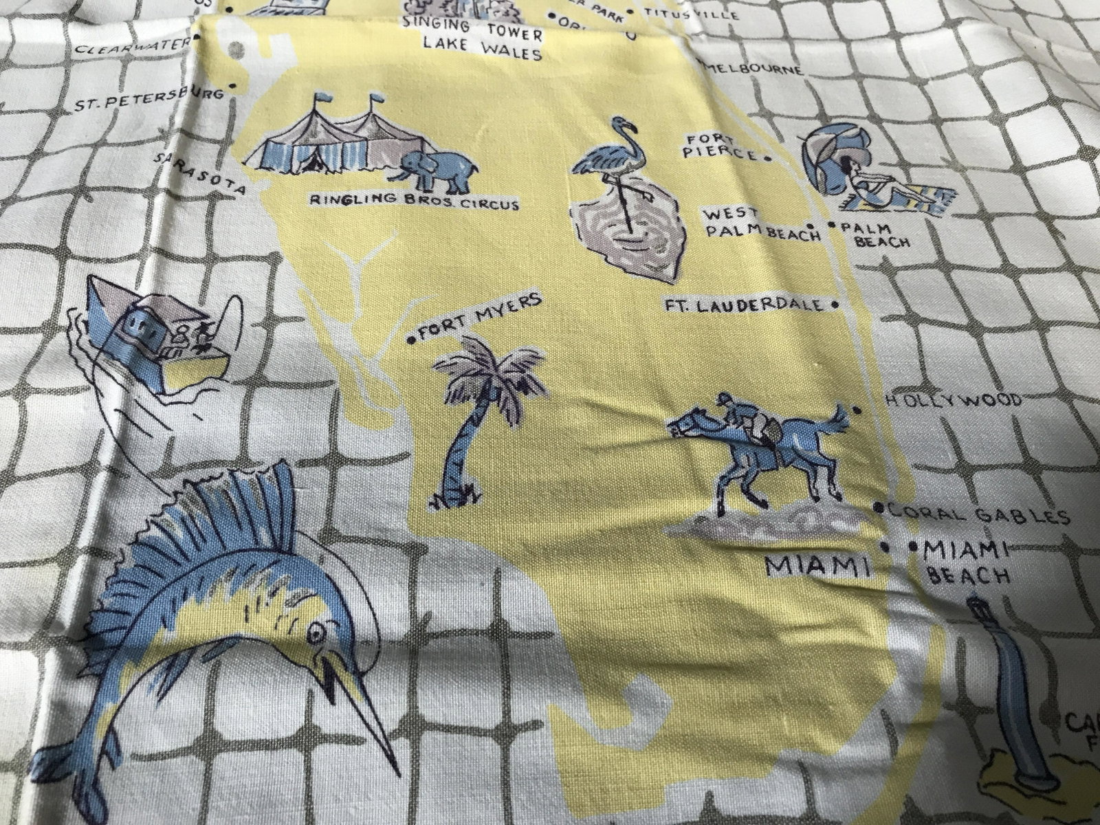 Vintage Map of Florida Table Linen: vintage map of Florida table linen, stains to cloth, cloth shows a net pattern with a map of Florida as well as a border of pictures that show the highlights of the state, Vintage table cloth, vintage