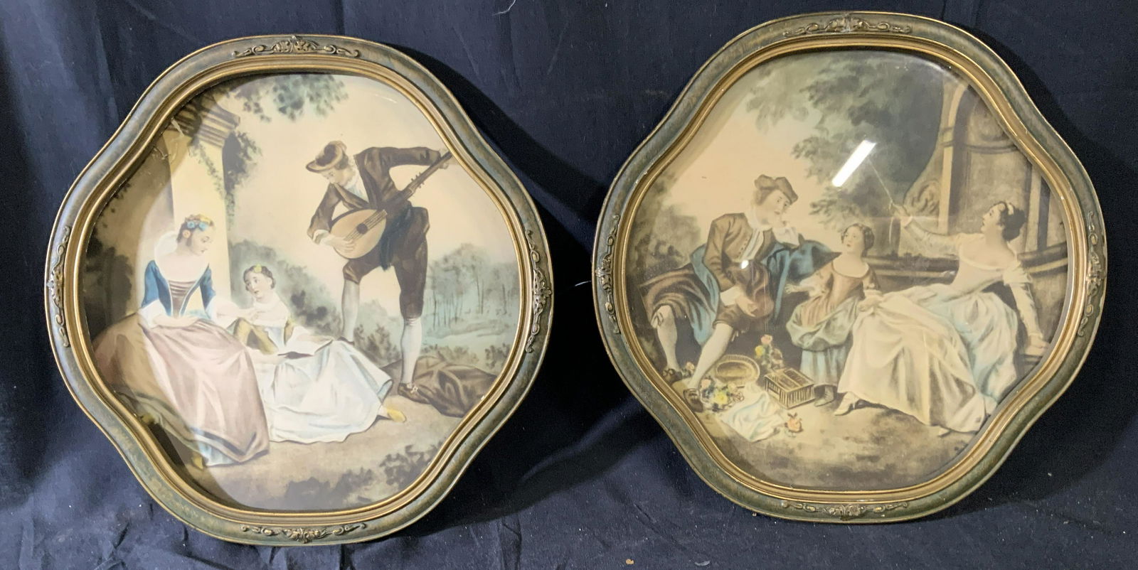 Set of Two Round Colonial Art Prints: Set of two round mixed portrait landscape, in the first depicts a figure in a garden scape playing lute for two onlookers, the second depicts two adults and one child also sitting in a garden setting
