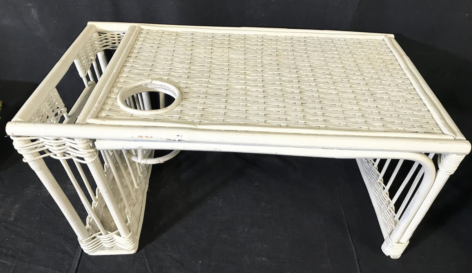 Vintage White Toned Wicker Breakfast In Bed Tray: Tray is white toned. Piece has woven wicker structure. Piece has handle on each side. Piece has platform, cup holder and storage area. Piece measures approximately 23 inches long 13 inches deep 10 inc