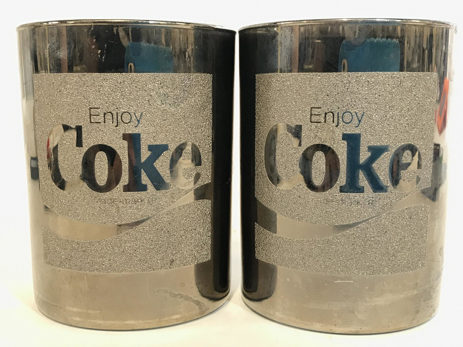 Pair Glass Vintage Silver Toned Coca Cola Cups: Lot includes 2 cups. Each are silver toned and reads ENJOY COKE. Vintage beverage ware, Coca Cola collectibles, Coca Cola cups, Coca Cola memorabilia, Barware, tableware, tabletop accessories, vintage