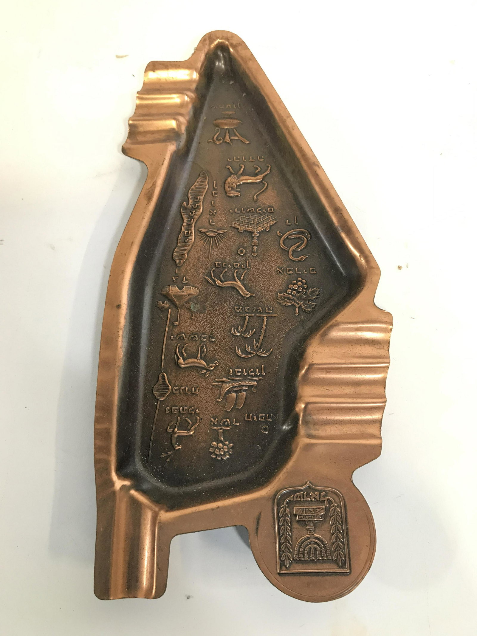 Vintage Copper Toned Judaica Ashtray: Ashtray is copper toned, possibly genuine copper. Piece has various beveled illustrations & Hebrew characters. 8.5 inches long 4 inches wide. Judaica, Hebraica, ashtray, Judaica ashtray, Hebrew Ashtra