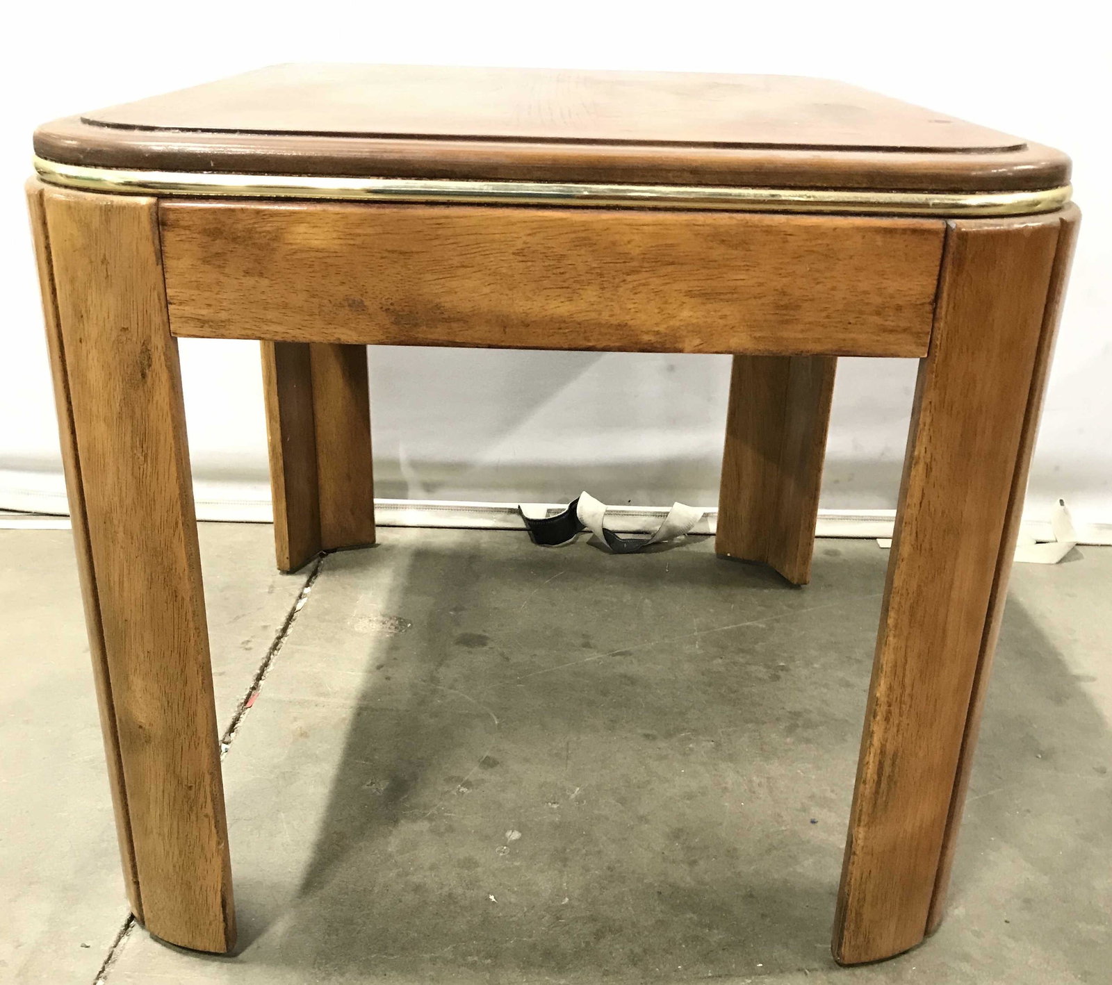 Vintage Wooden Side Table: Side table is vintage. Piece is tan toned and wooden. Piece has gold toned accent detail around edges of table top. Side table, end table, wooden side table, vintage side table, lamp table, living roo