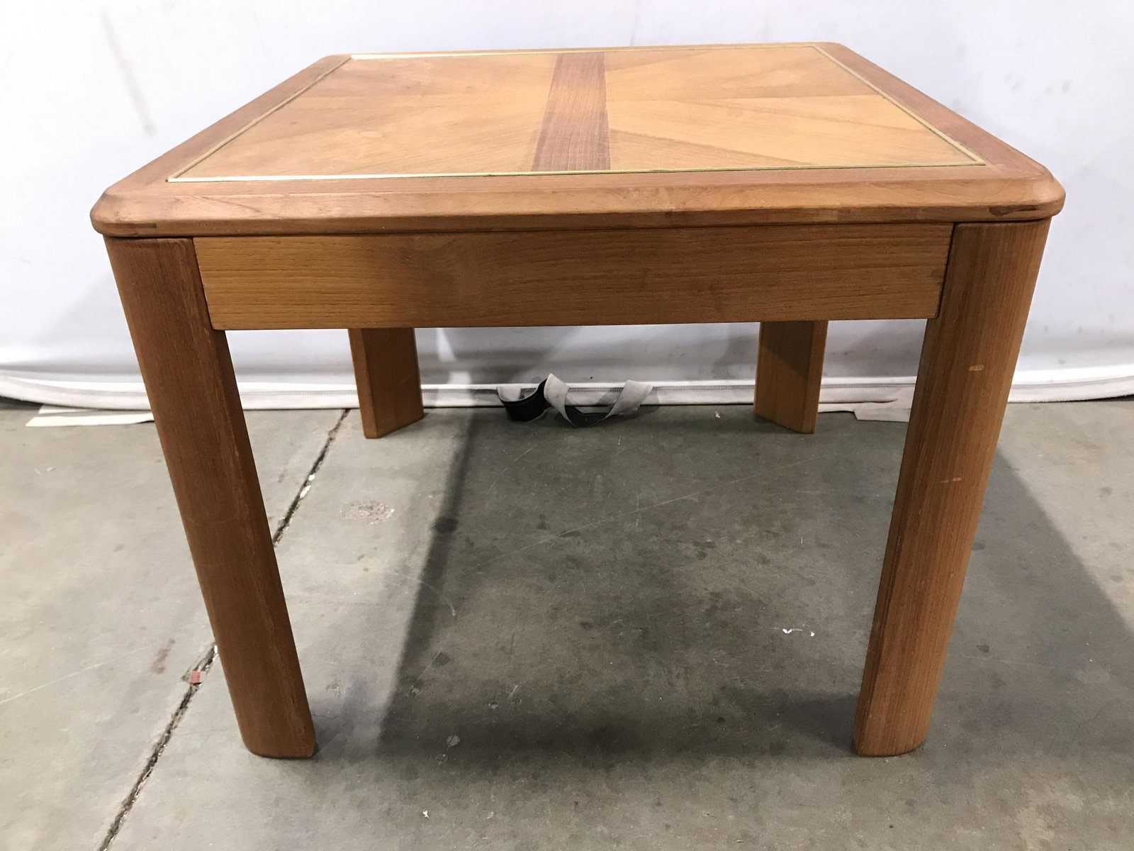 Vintage Wooden Side Table: Side table is vintage. Piece is tan toned and wooden. Piece has gold toned accent detail around edges of table top. Side table, end table, wooden side table, vintage side table, lamp table, living roo
