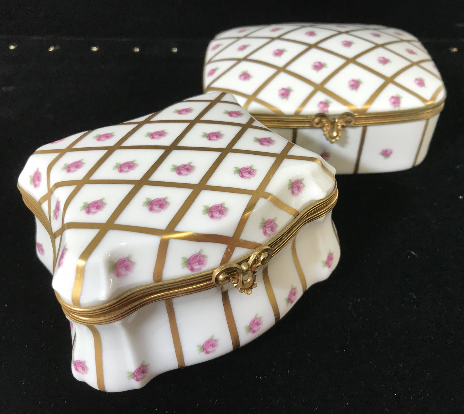 PAIR LIMOGES FRANCE Rose & Gilt Trinket Boxes: Signed Limoges boxes, lids on hinge, delicate pink rose pattern with Linear gilt diamond pattern. Ornate Clasp. Boxes have different shapes. Underside reads Limoges a France in aqua ink. 4 1/4 x 3.5 i
