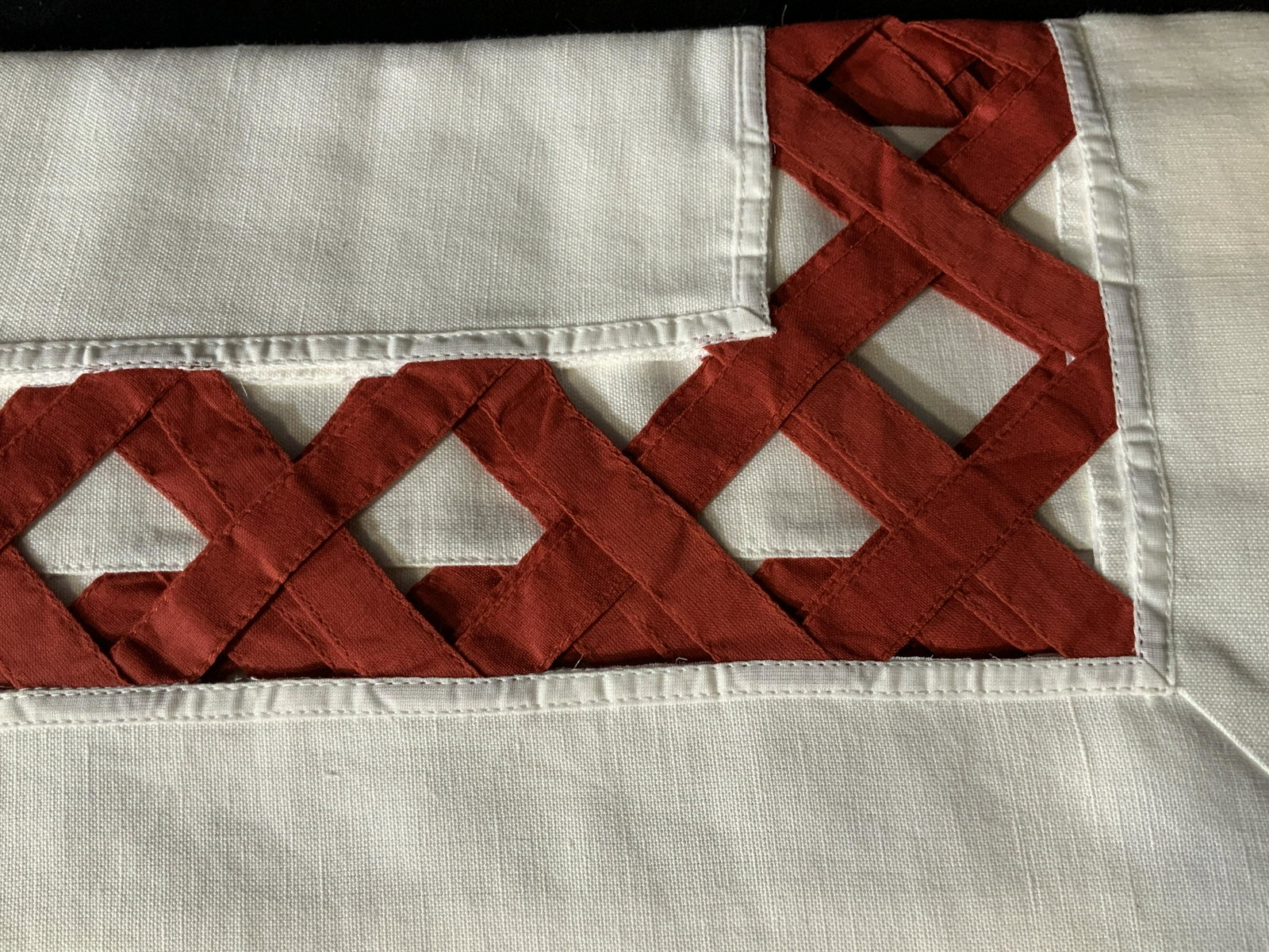 Set of Three Decorative Table Cloths: Set of three large table clothes in white with a red peek-a-boo basket pattern around the edge of the table where it hangs over the side of the table, made of linen the basket pattern is in a chili re