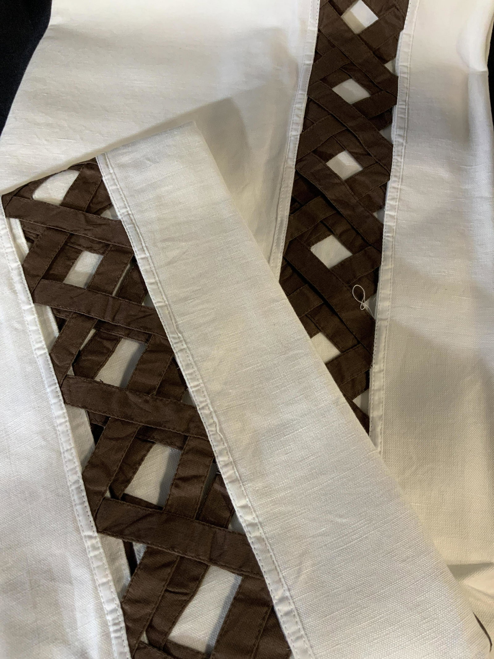 Set of Two Decorative Tablecloths: Set of two large table clothes in white with a red peek-a-boo basket pattern around the edge of the table where it hangs over the side of the table, made of linen the basket pattern is in a chili red,