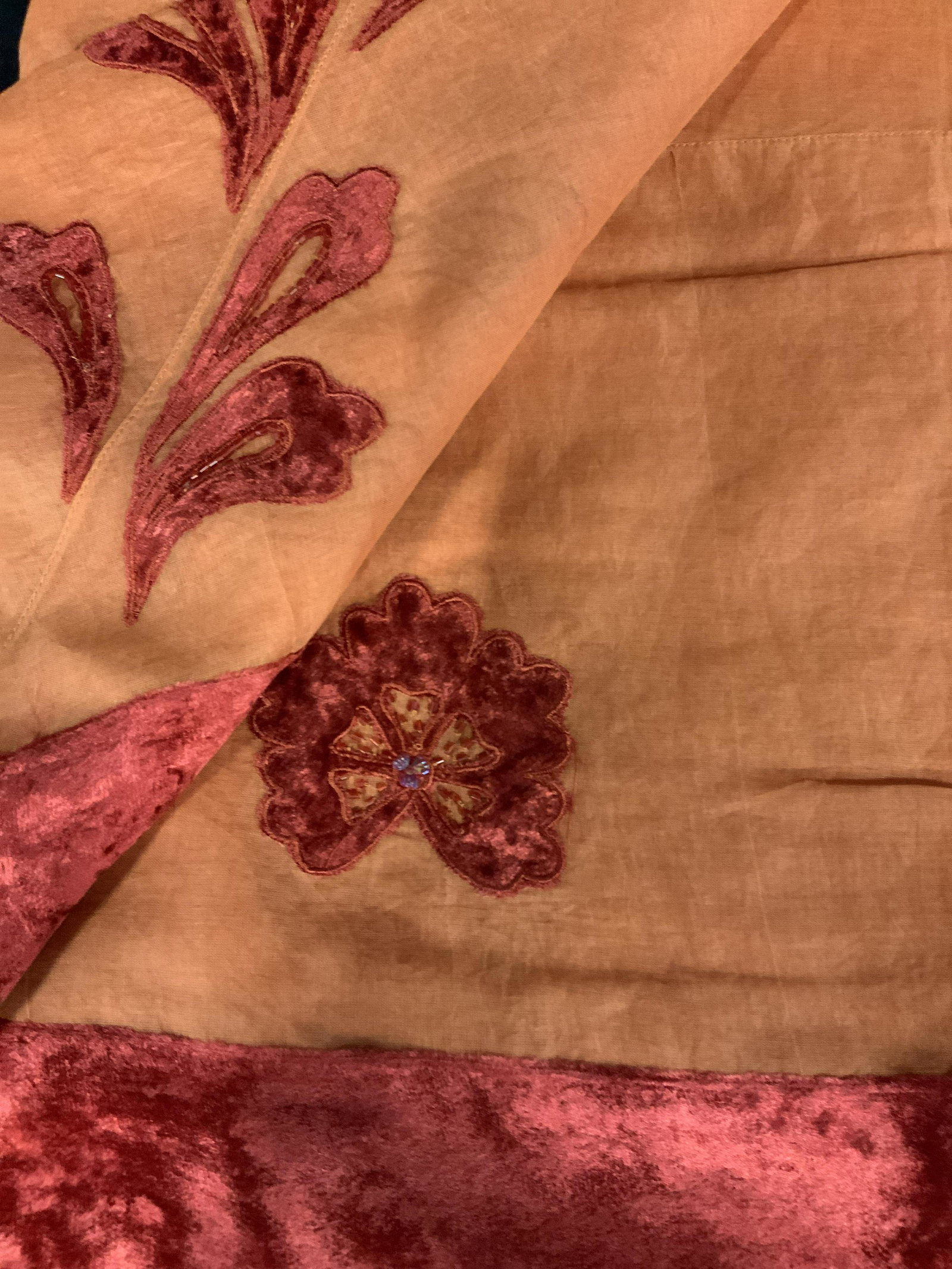 New in Packaging Set of Two Decorative Tablecloths: large table cloths in orange with a red felted velvet floral pattern and beading around the edge of the table where it hangs over the side, made of linen the this table cloth comes with its own fabric