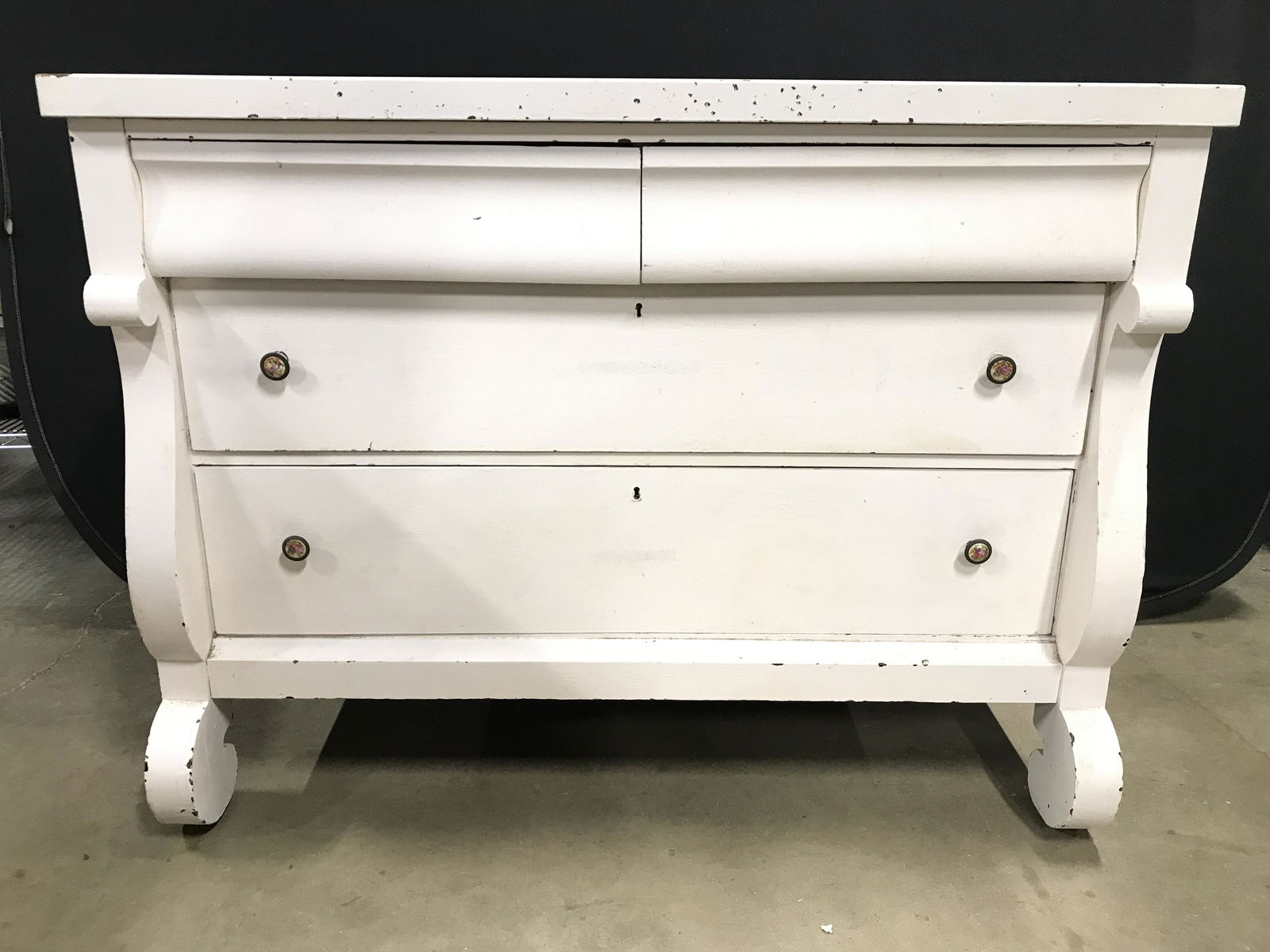 Antique White Toned Wooden Dresser: Dresser is white toned and wooden. Piece has 4 drawers. Each drawer has hand dovetailing. Drawers have petite knob style handles which appear to possibly have mother of Pearl detail. Dresser, white dr