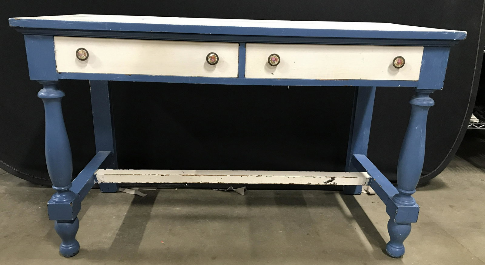 Vintage Wooden Children’s Desk: Desk is wooden and vintage, possibly antique. Piece is blue and white toned. Desk has 2 drawers each with 2 petite knob style handles which appear to be have porcelain detail. Drawers have hand doveta
